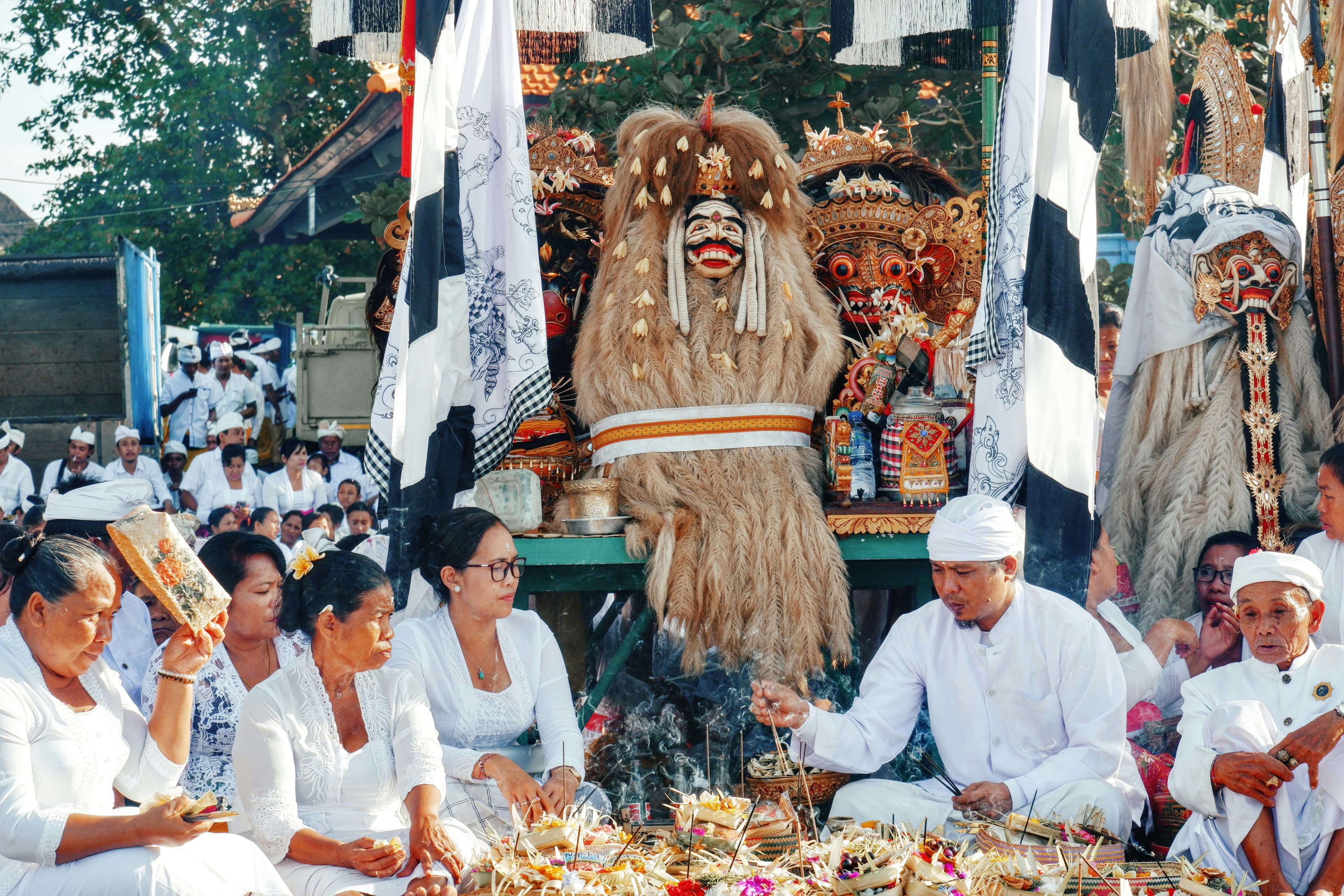 Local people of Bali sitting next to each other in front of a festival parade for Nyepi in Bali