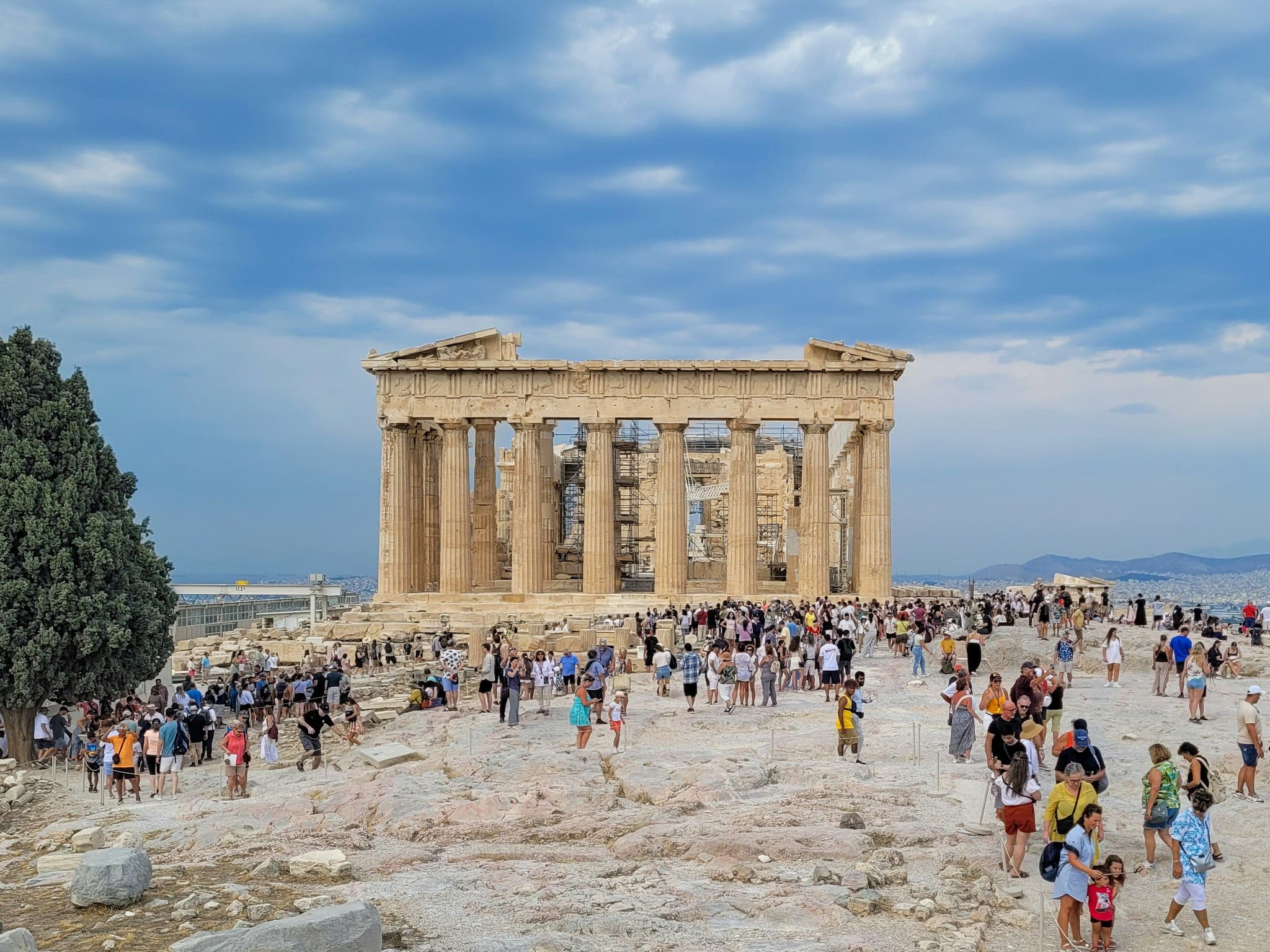 People and tourists walking in front of the Parthenon in Greece