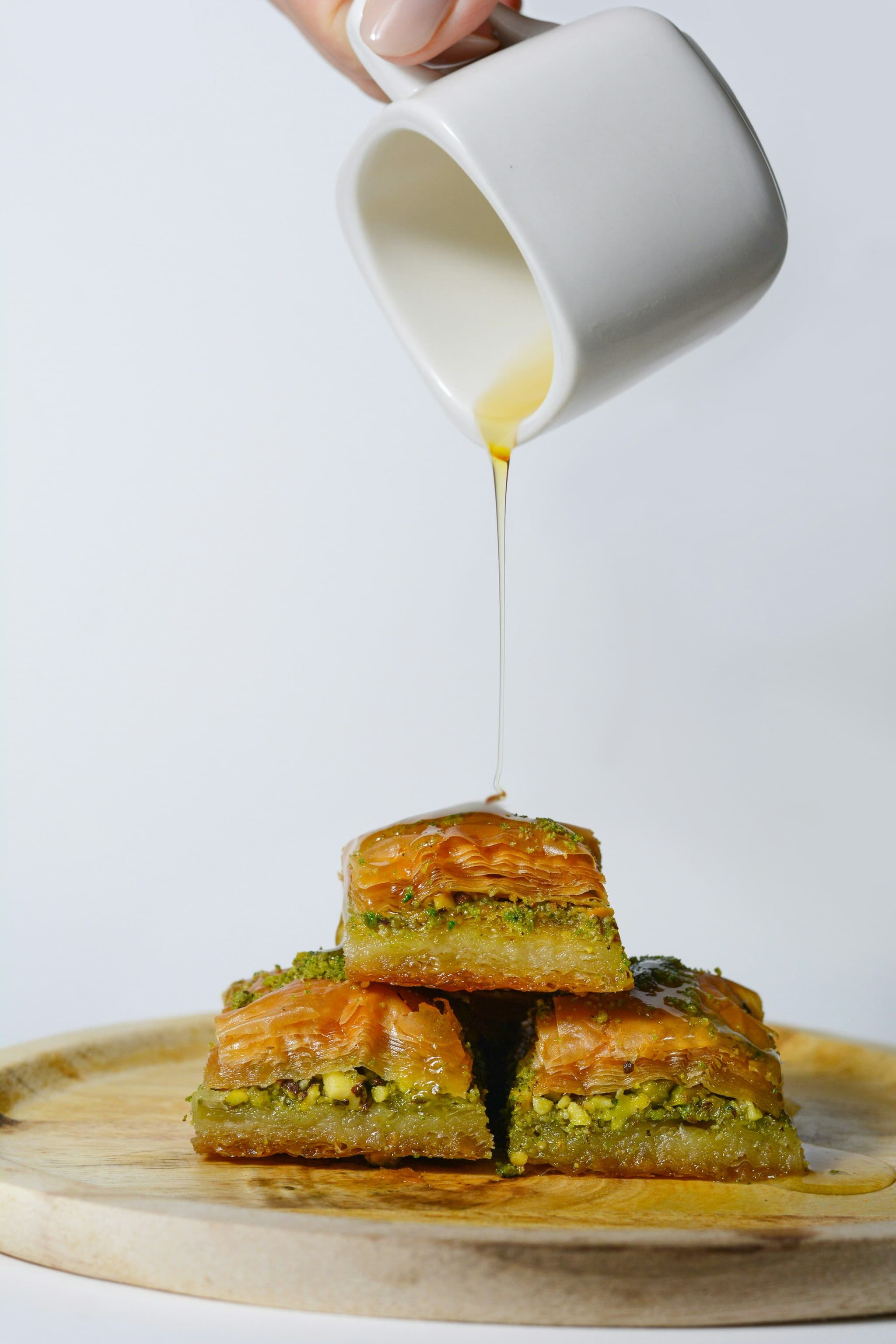Pistachio baklava with syrup being poured over it