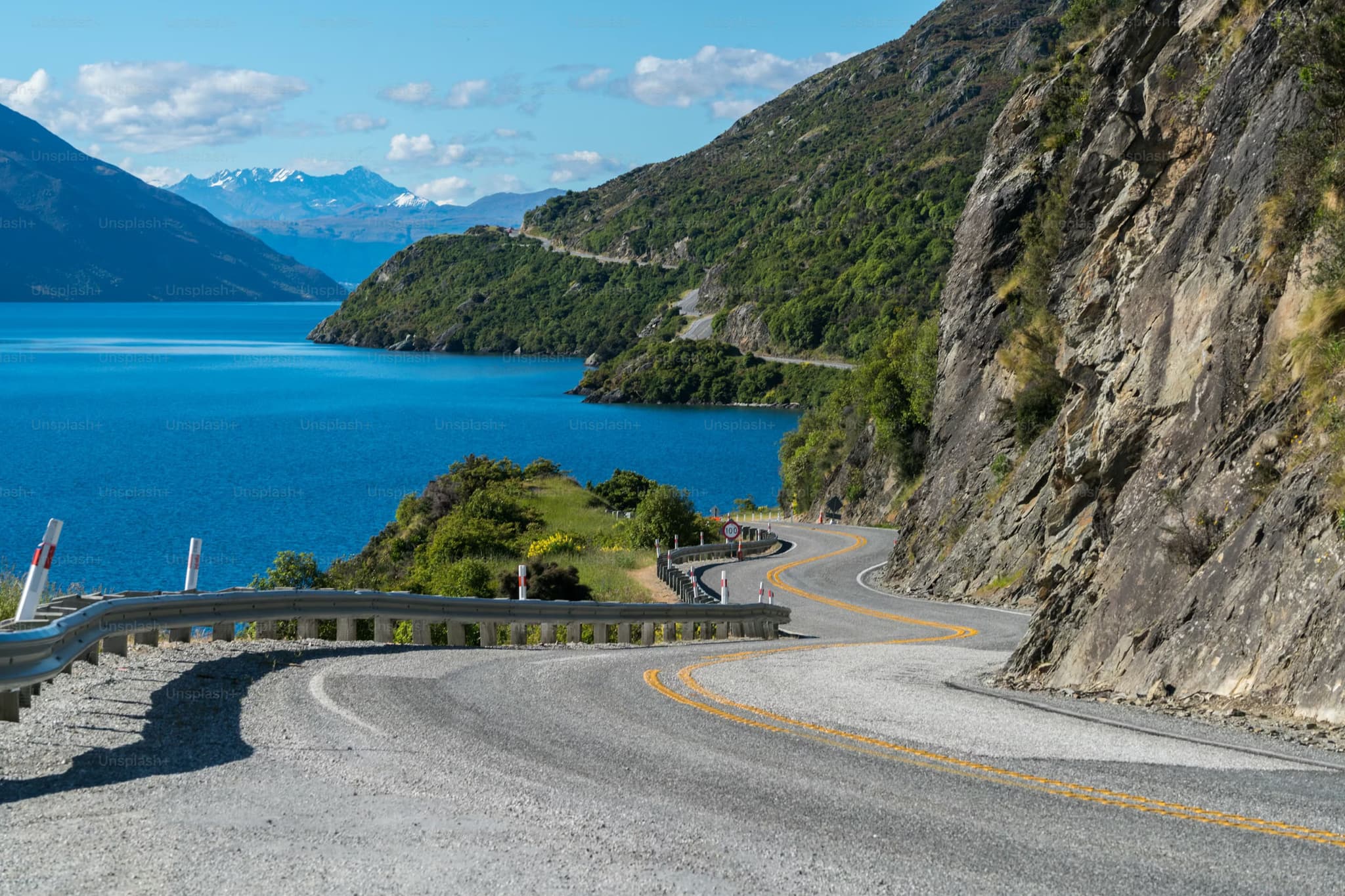 Summer in new zealand a windy road next to mountains and lake