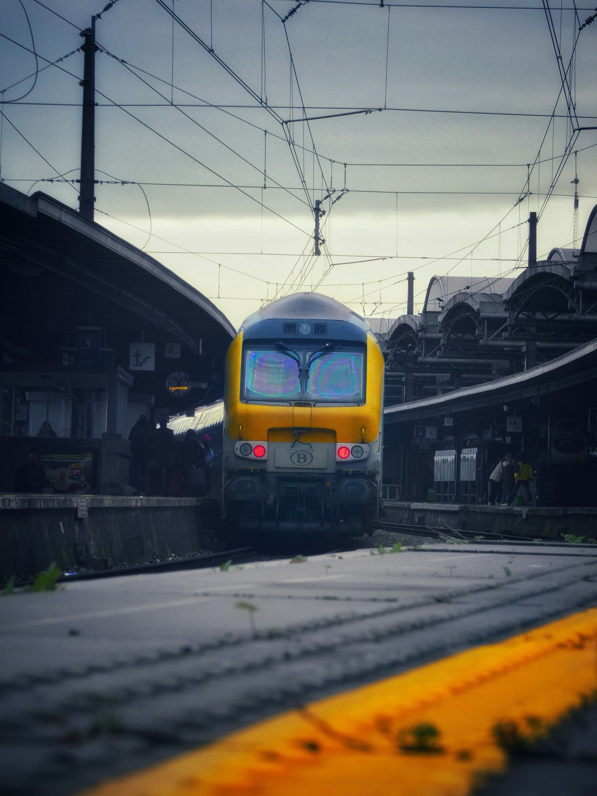 A double-decker passenger train waiting at a station platform