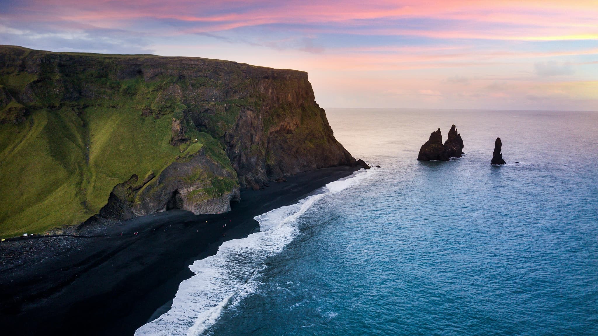Aerial view of cliff and ocean in Reynisfjara during sunset