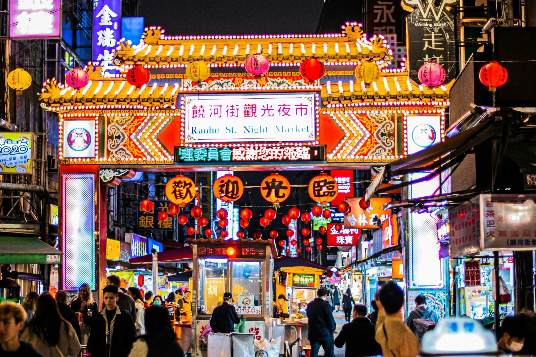 Crowds walking through Raohe Night Market in Taipei at night
