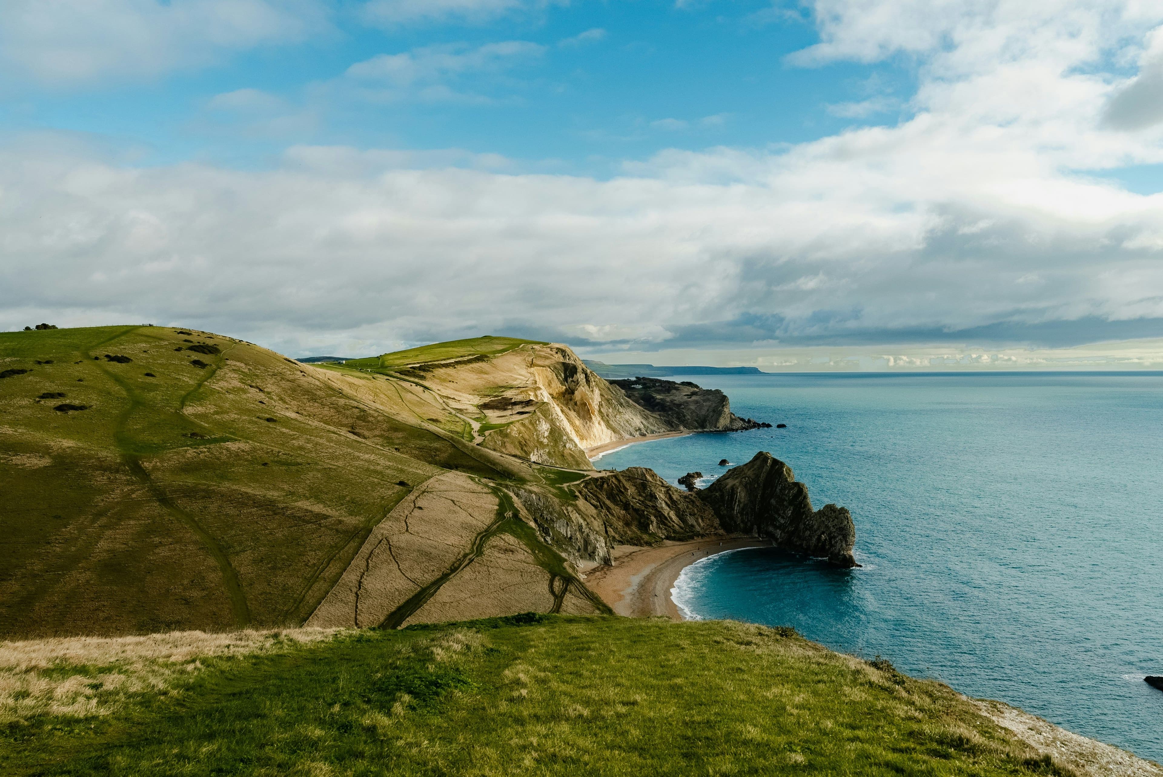 Jurassic Coast in England, green lush hills and dunes next to the coastline