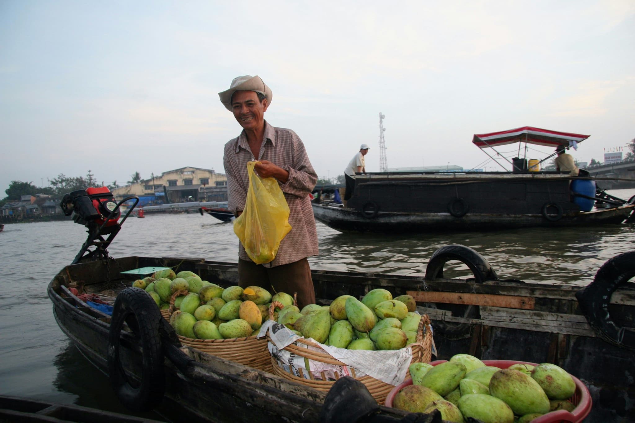 Local vietnamese man smiling ona biat with fruits
