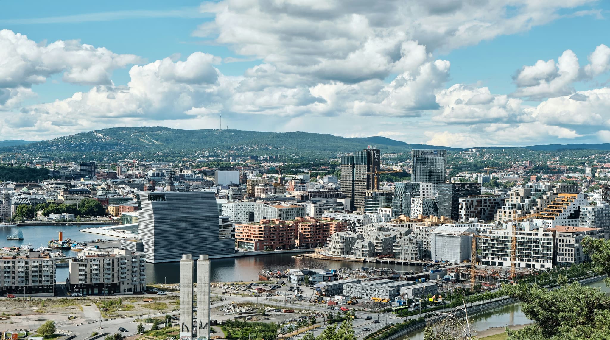 The city of Oslo from above, with city buildings, parks, roads and mountains in the background