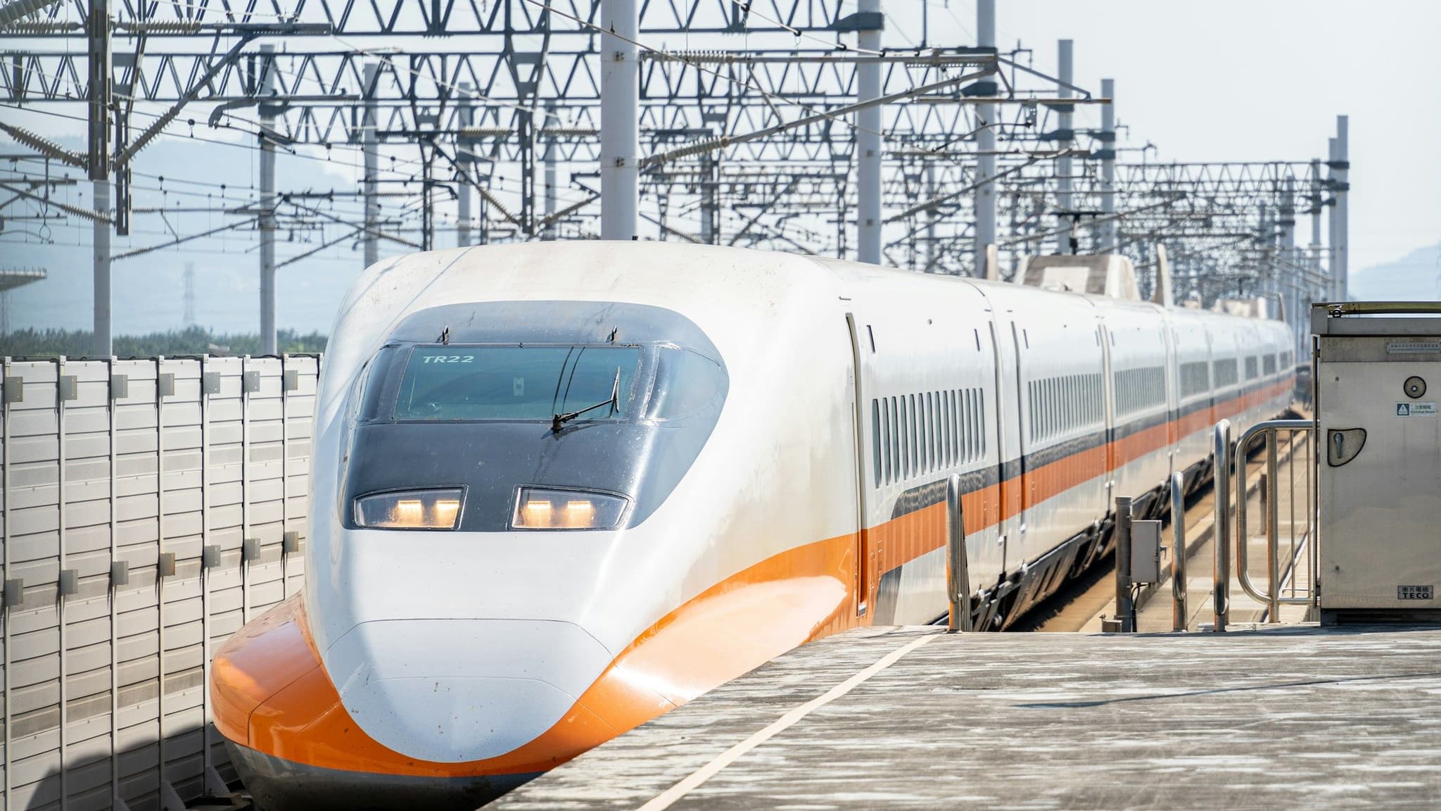A white and orange high-speed train on the tracks in Taiwan