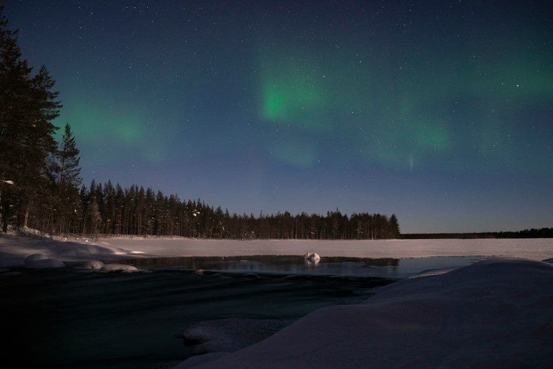 The northern lights reflected over a lake in Finland on a clear night.