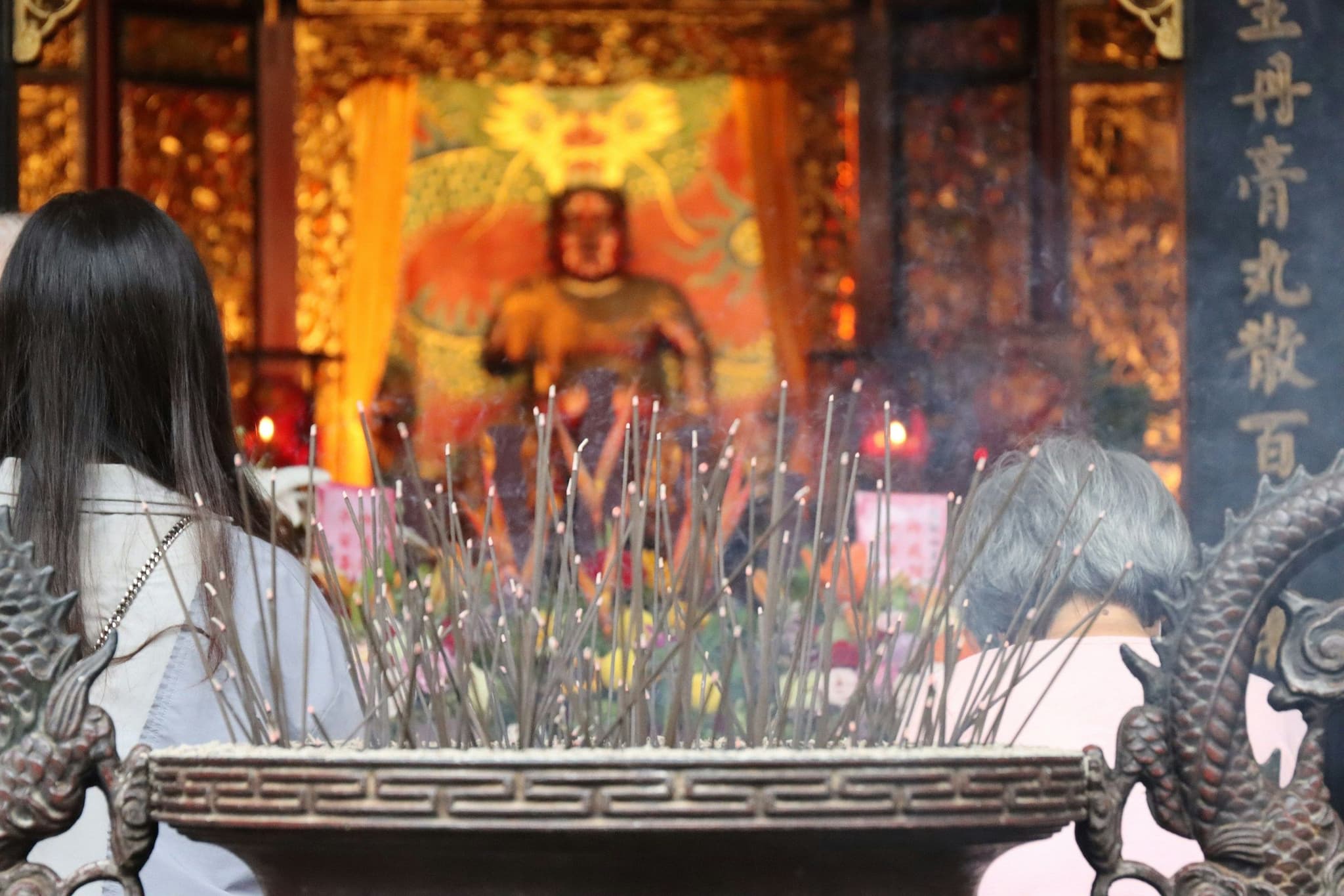 Incense smoke rising in front of a temple altar