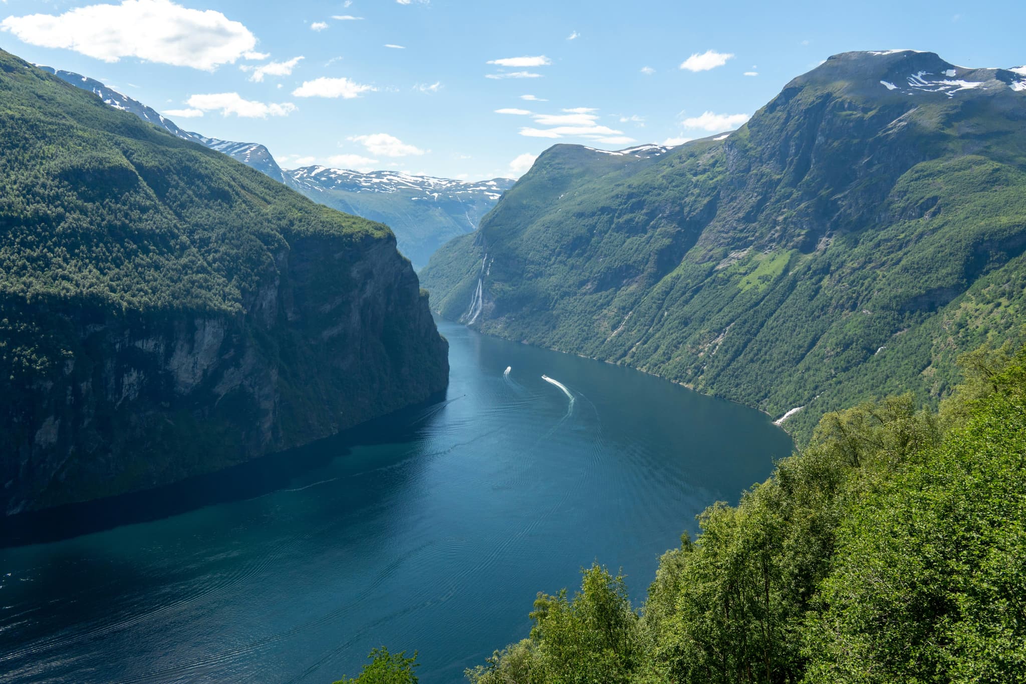 A big lake surrounded by high green mountains in Geirangerfjord