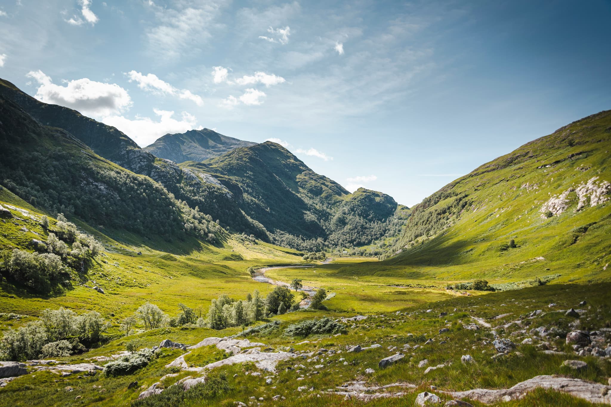 A picture of green landscape surrounded by hills and mountains in Glencoe and the Scottish Highlands
