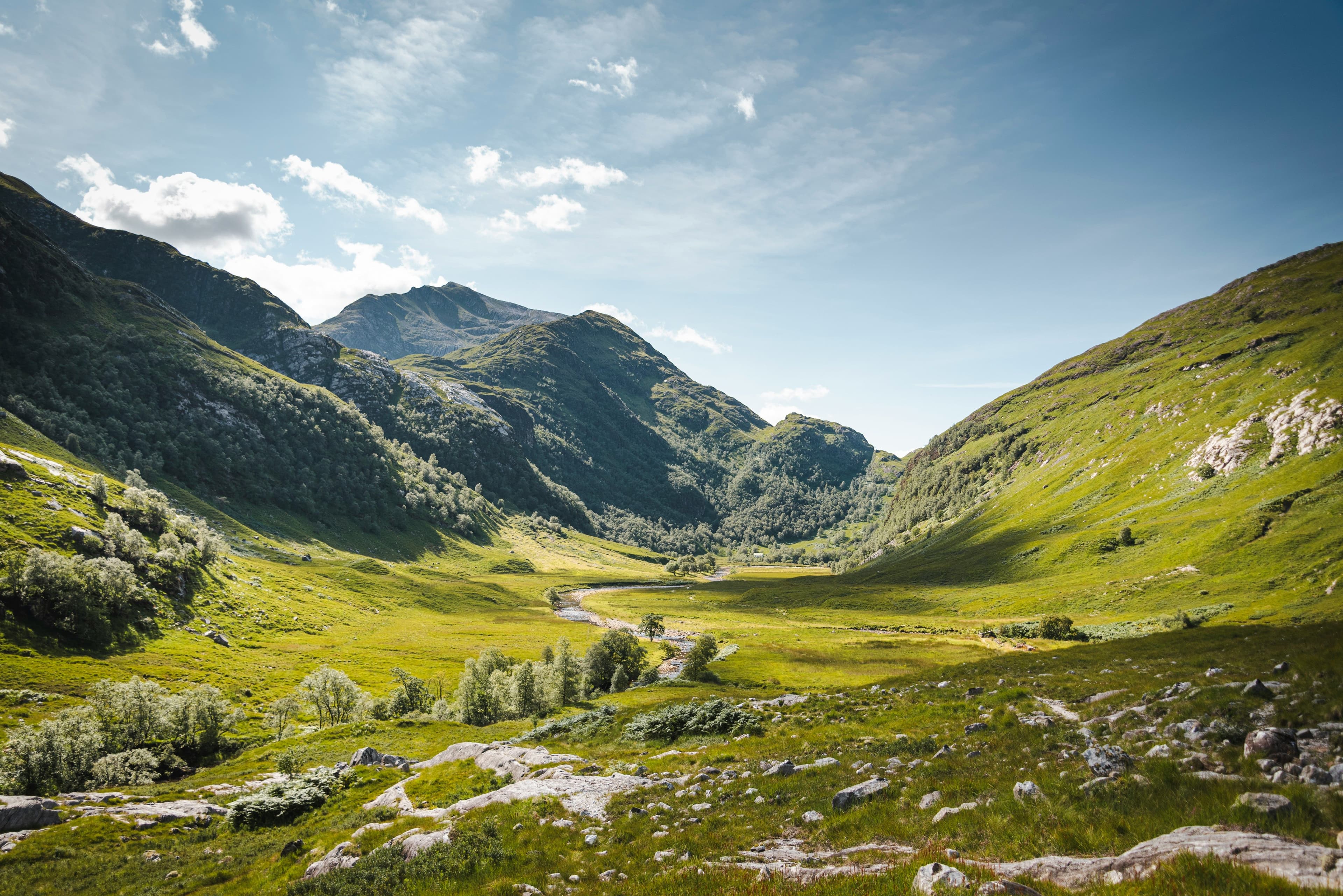 A picture of green landscape surrounded by hills and mountains in Glencoe and the Scottish Highlands