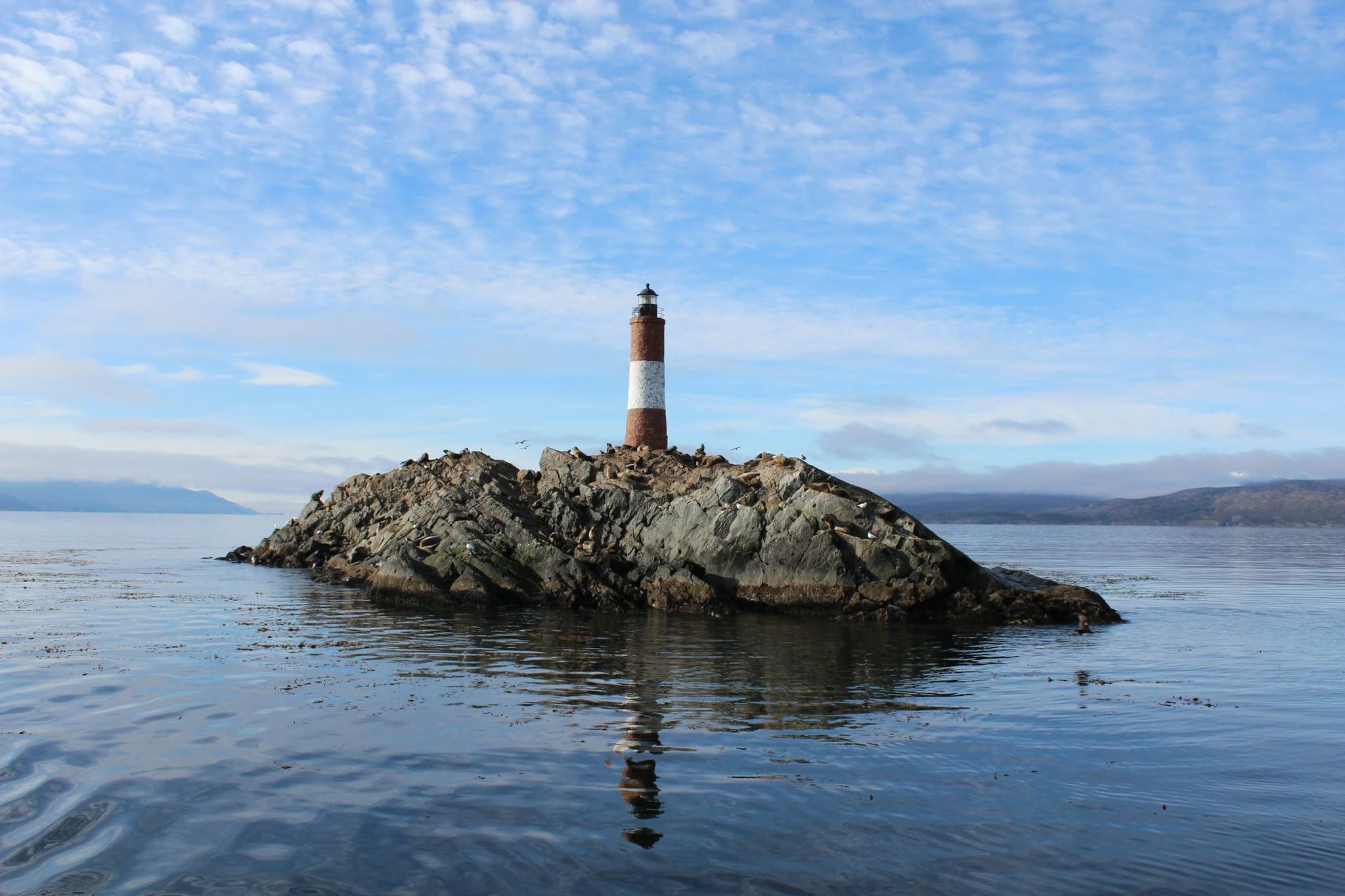 The red-and-white Les Eclaireurs lighthouse on a rocky islet in the Beagle Channel