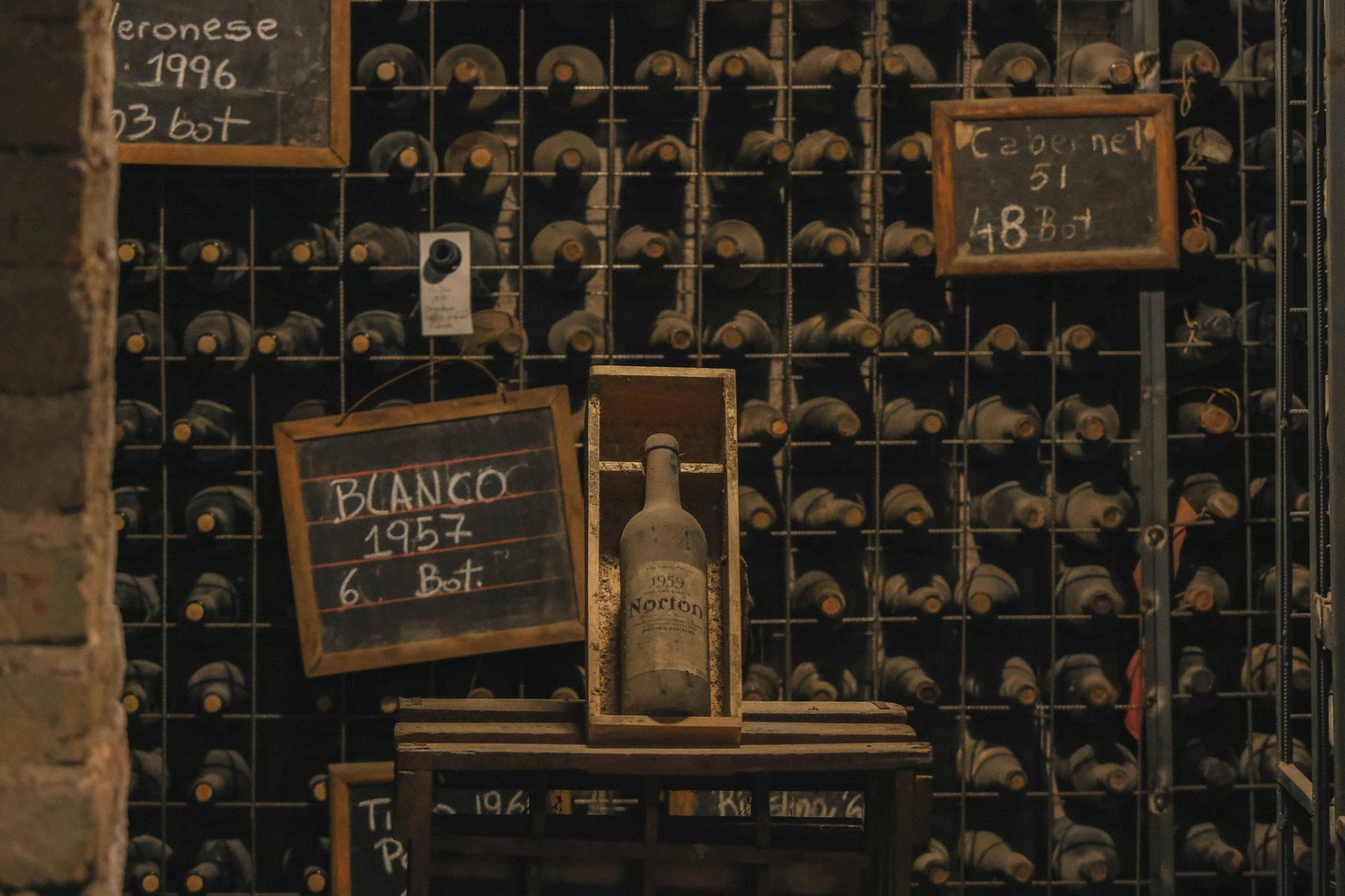 Wine bottles stored in a winery cellar with chalkboard labels
