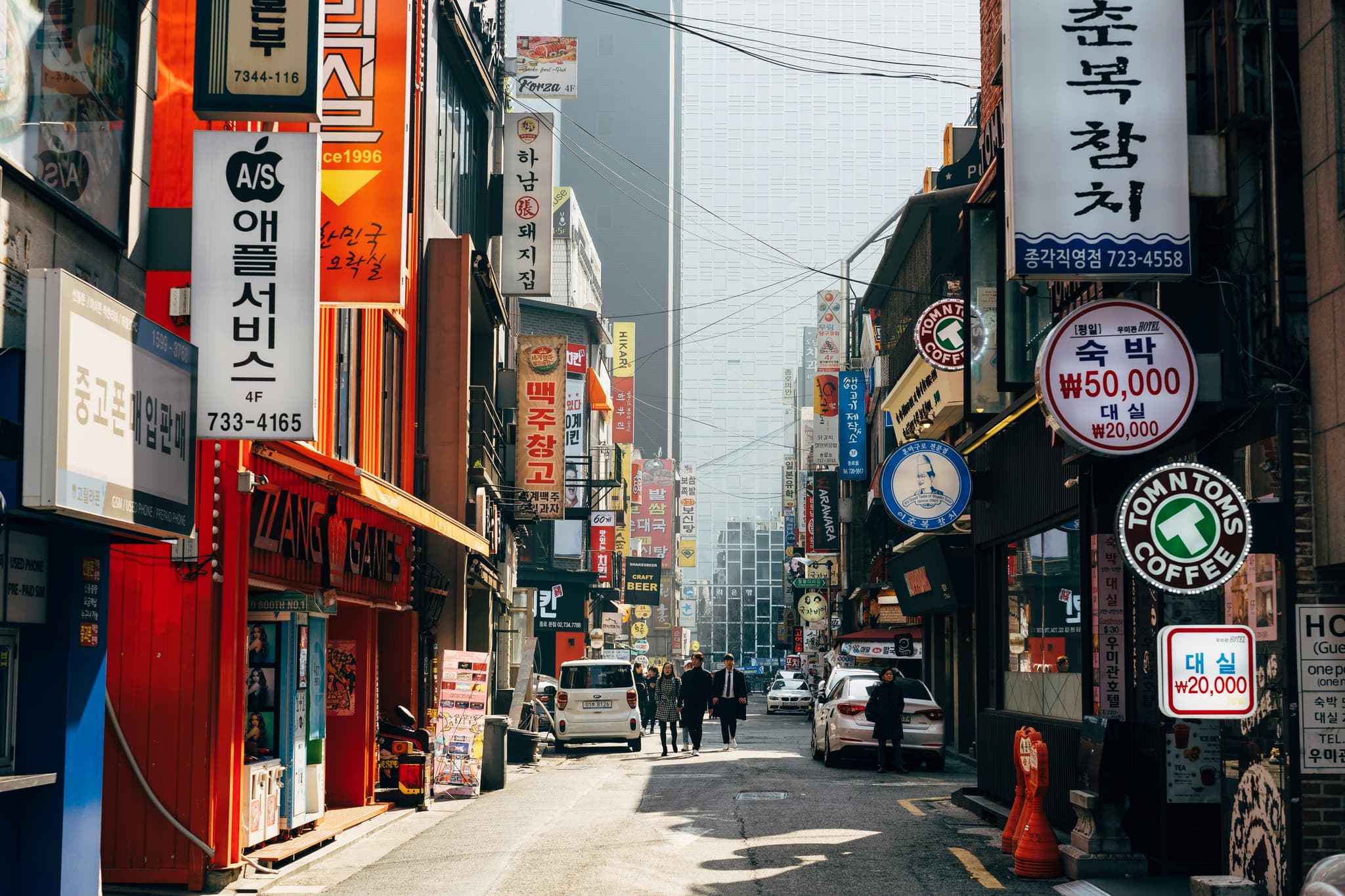 A shopping street with signs of shops and billboards on a clear day