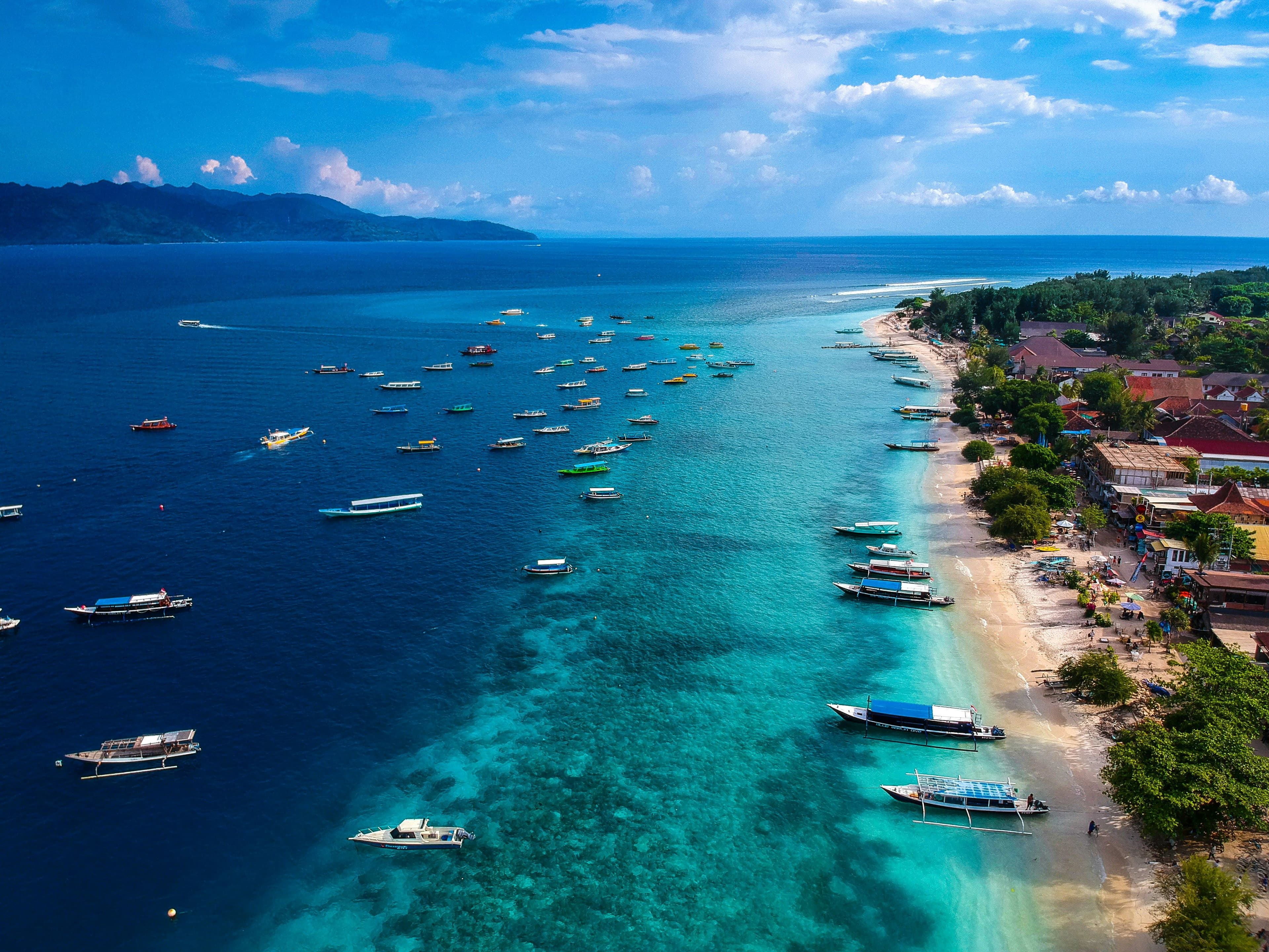 Aerial view of tropical island with deep sea and boats