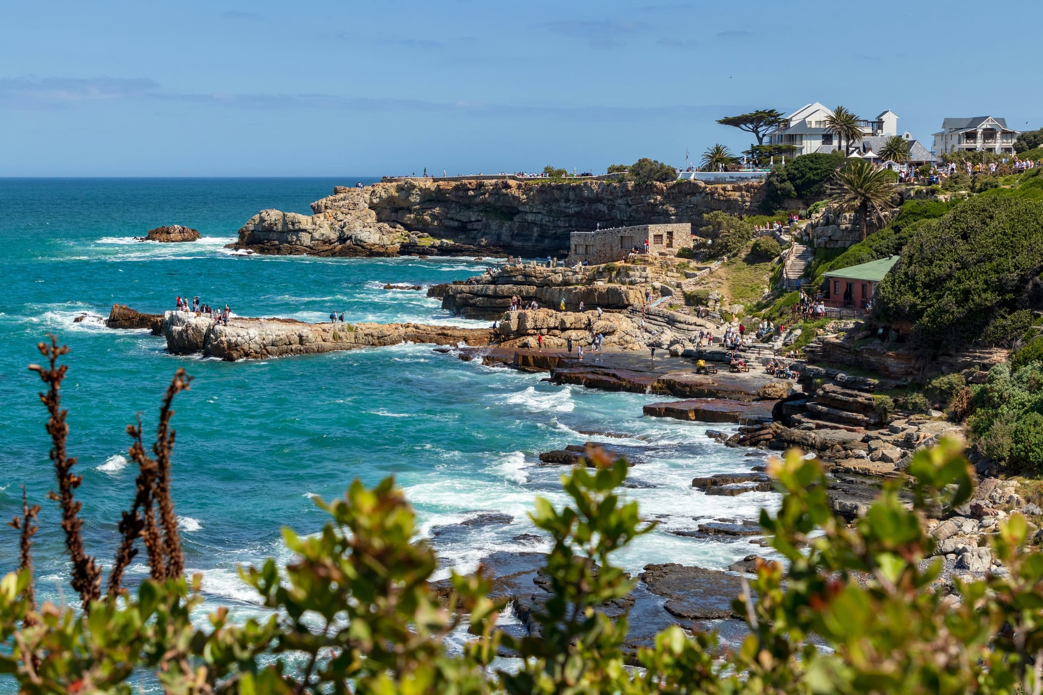 Coastal area with turqoise sea water and beach in Hermanus