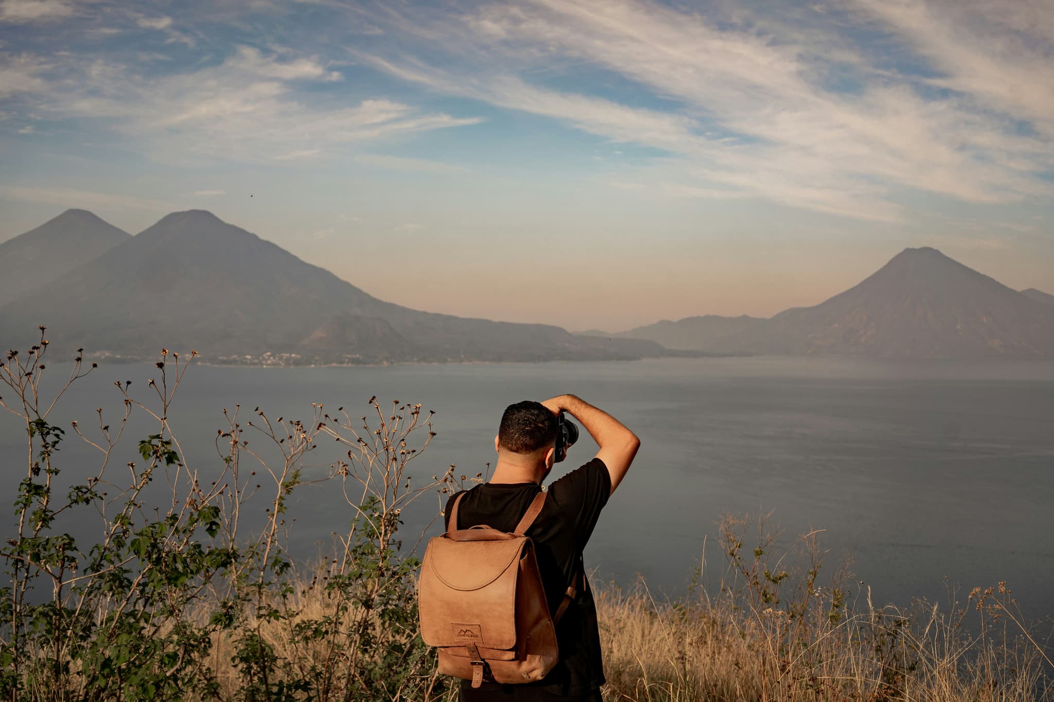 Solo traveller taking pictures of mountain and lake in guatemala