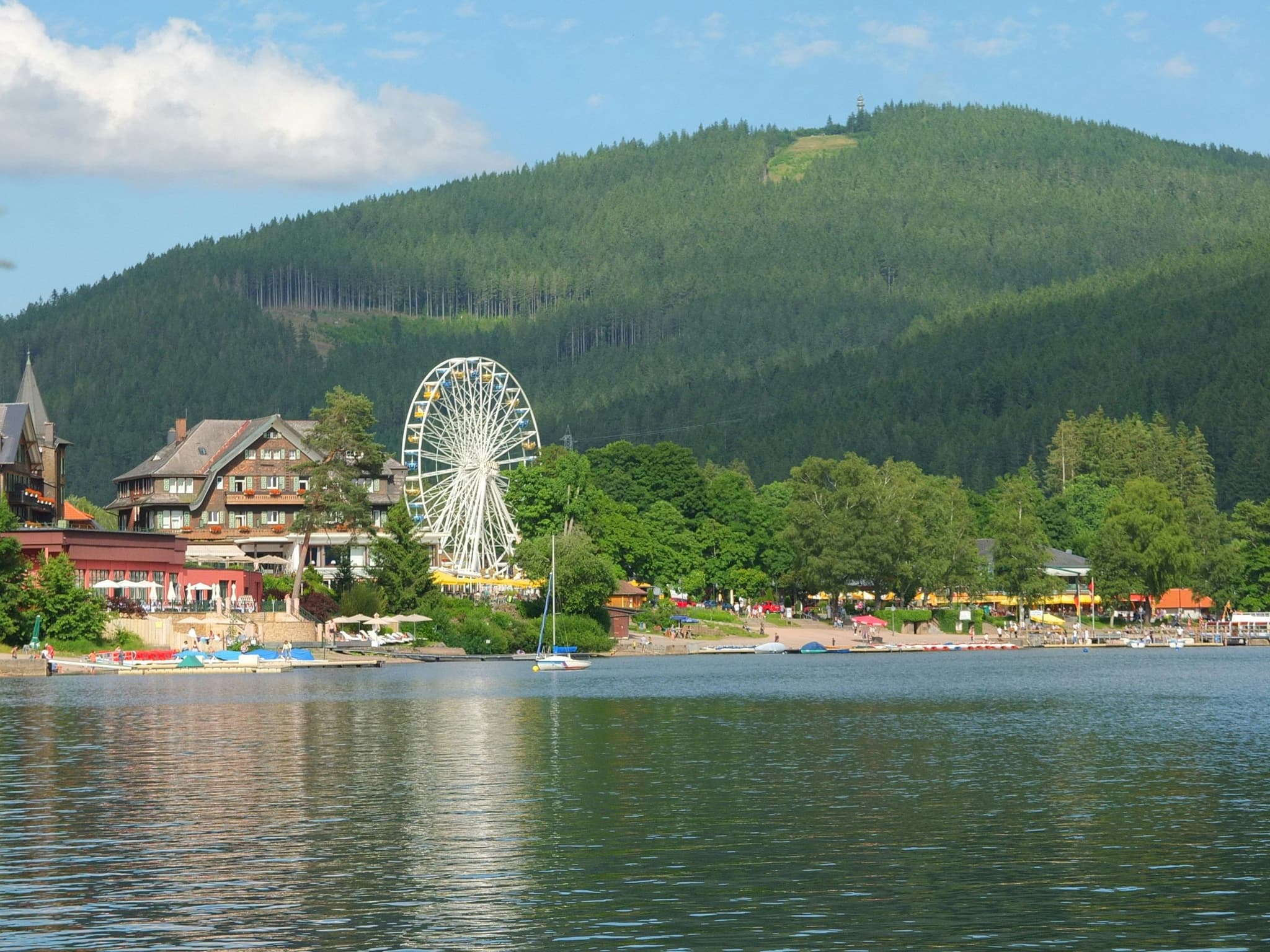 The clear waters of Lake Titisee surrounded by forested hills in Germany's Black Forest