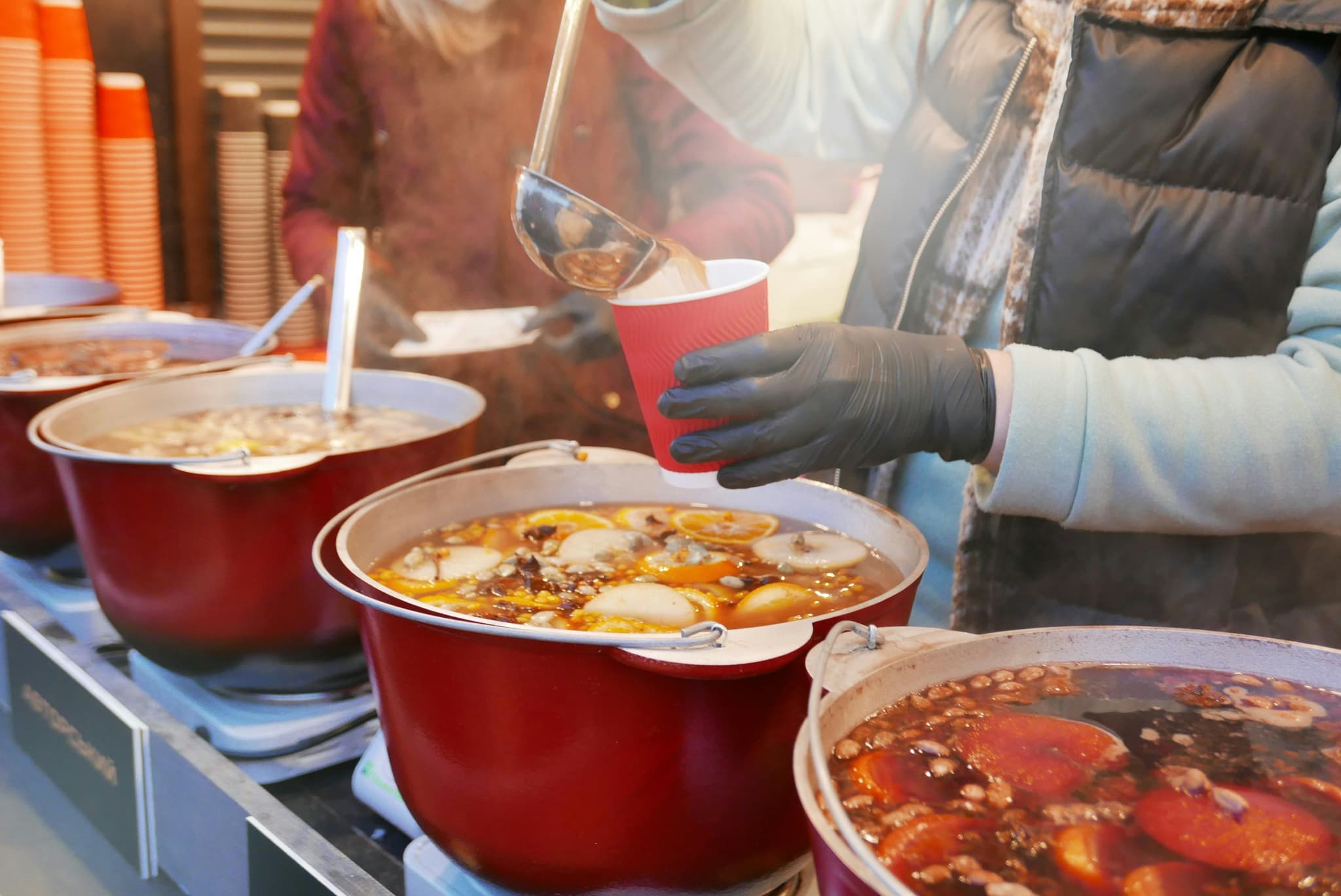 Mulled wine market stall, a hand pooring Mulled wine into a cup