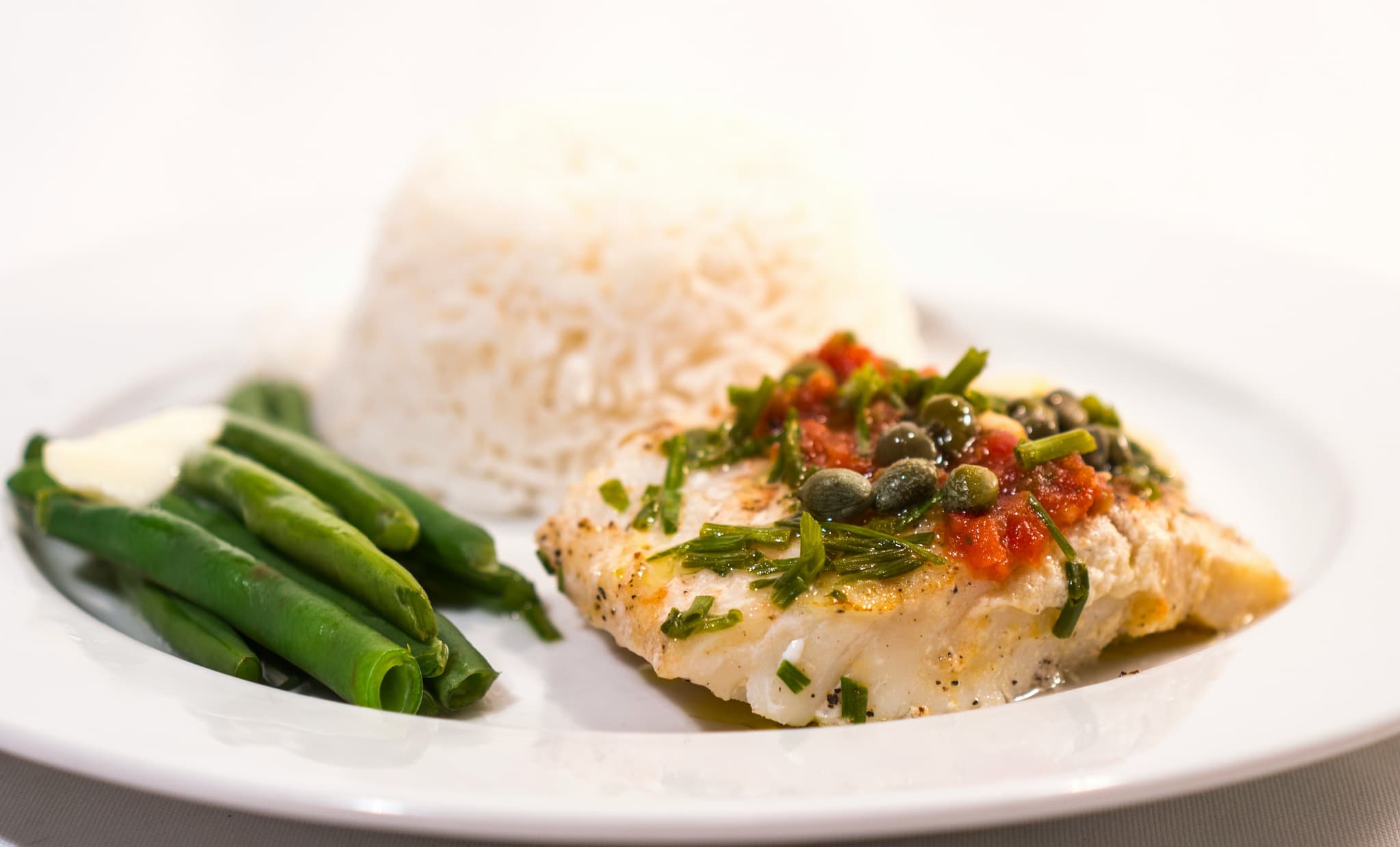 Plate with cod and green beans and rice.