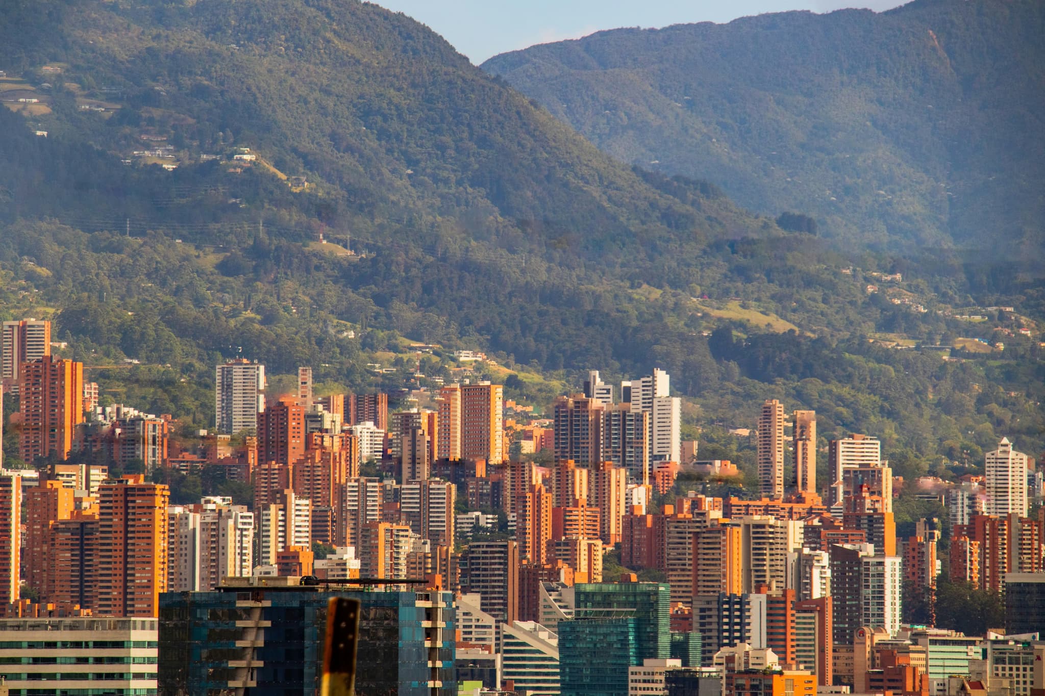 Aerial view of city of Medellín with orange houses and mountain backdrop