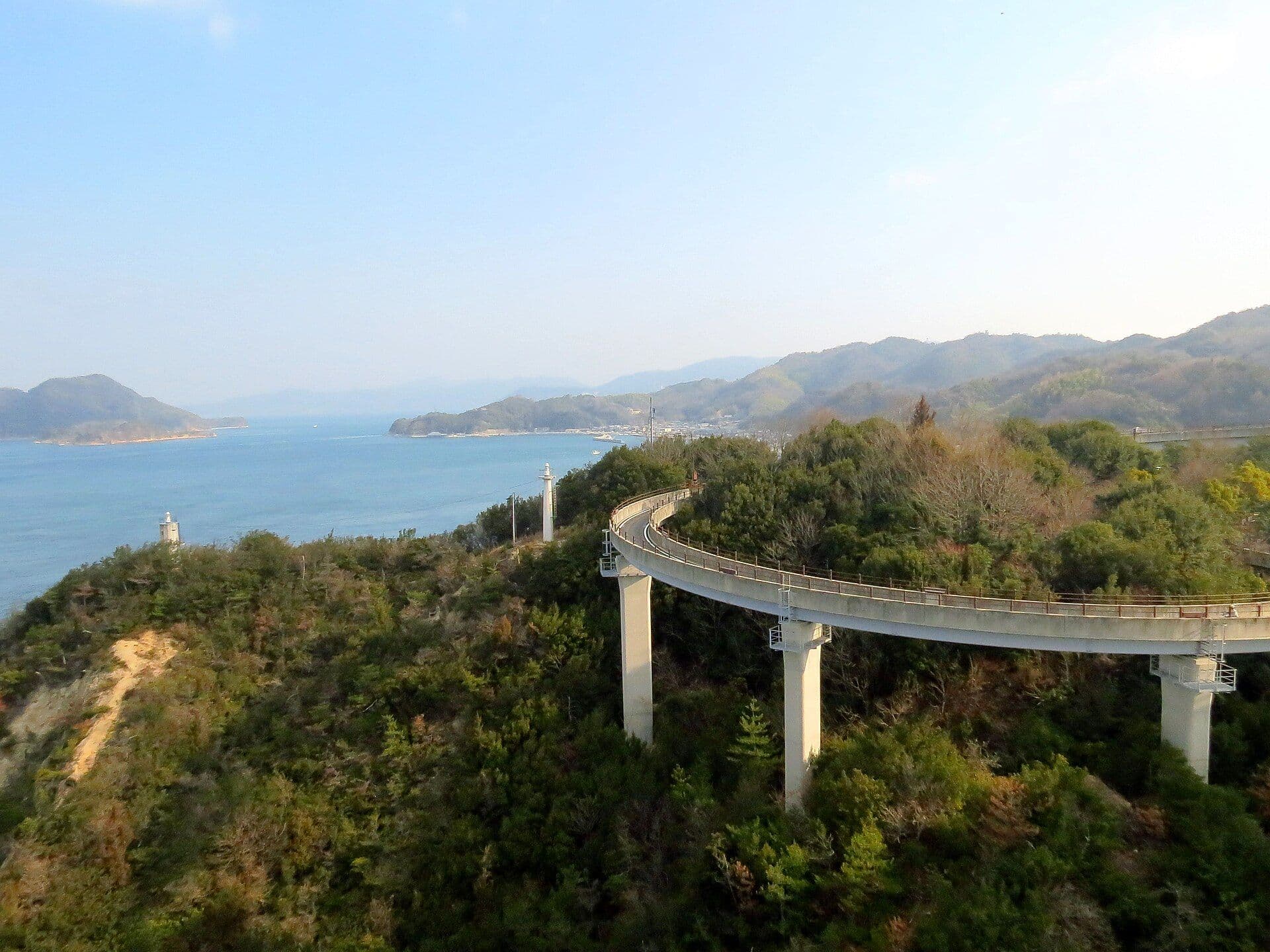 A curved bridge high in the air in the forest of Shimanami Kaido