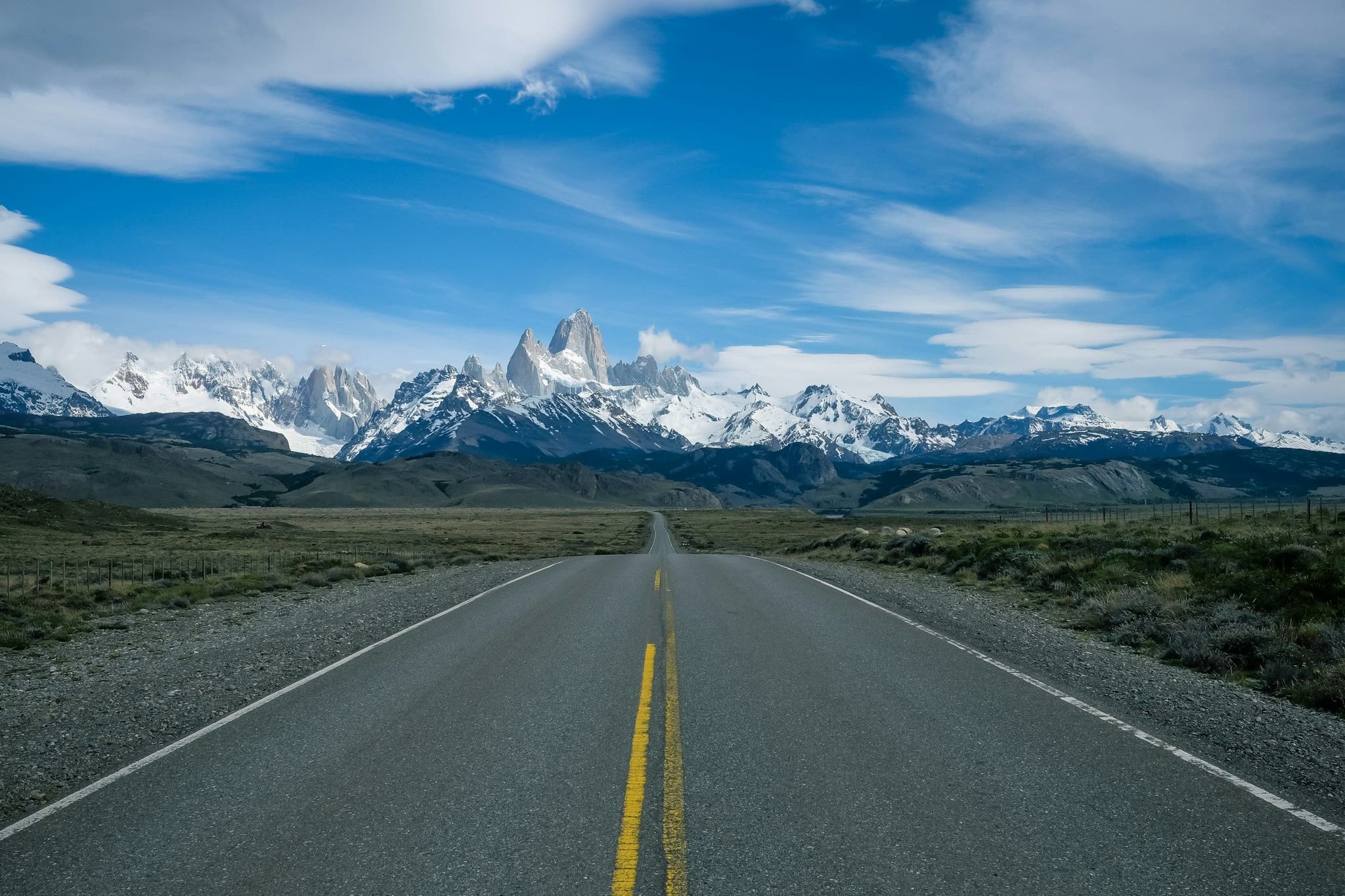 A road crossing the Patagonian steppe with Fitz Roy in the distance