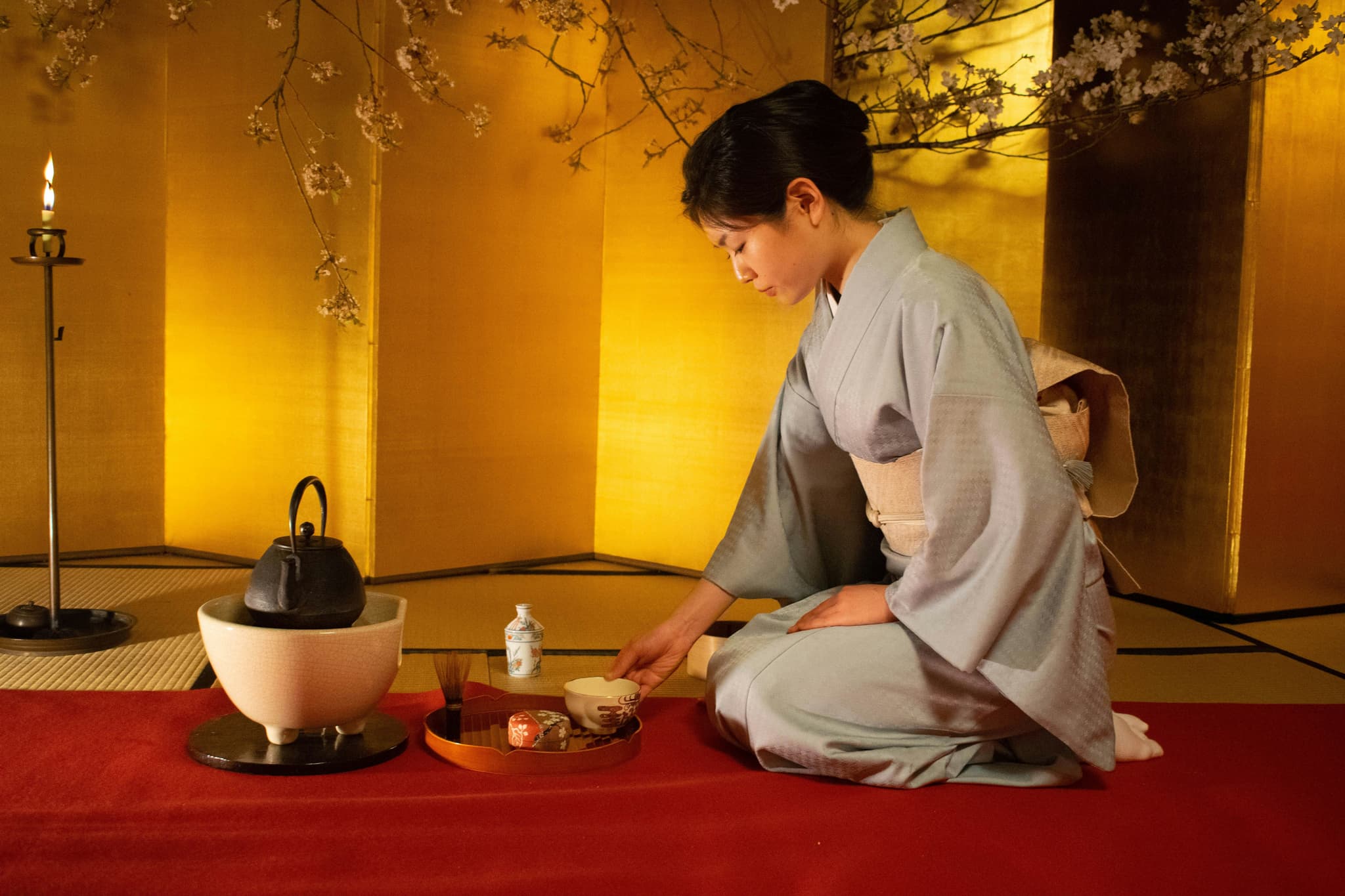 A woman preparing matcha during a traditional Japanese tea ceremony