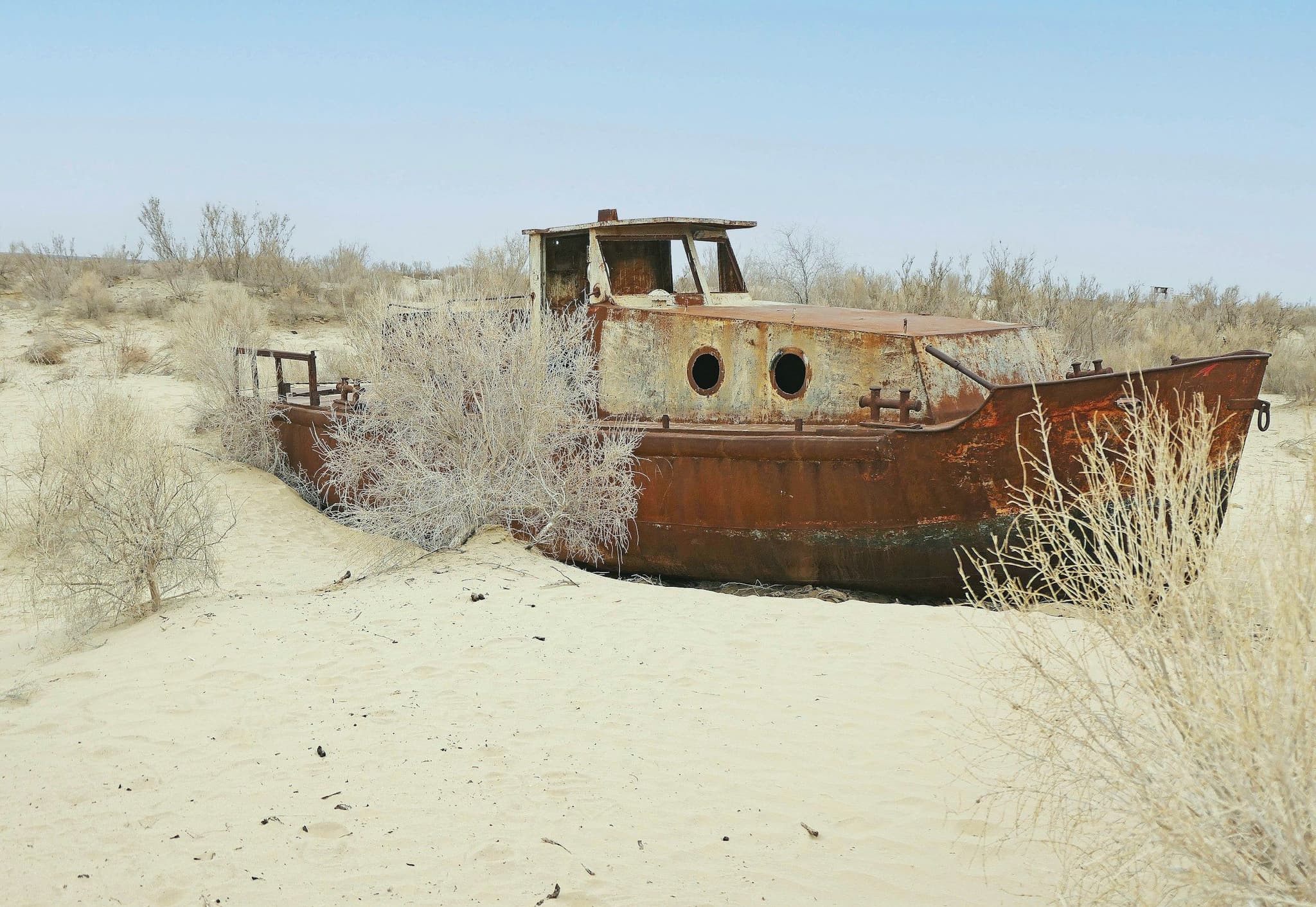 A rusting ship stranded on the dry sand of the former Aral Sea