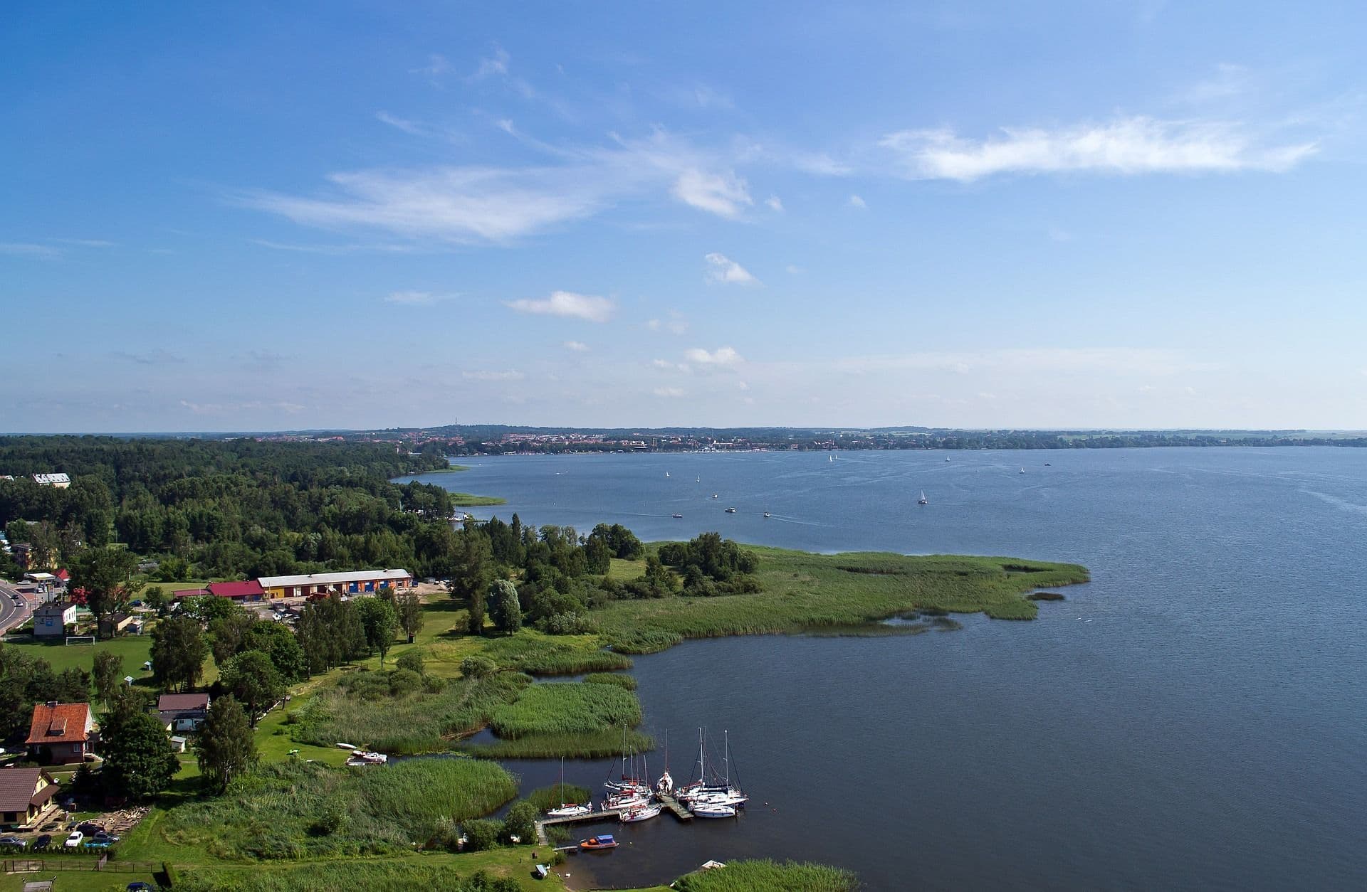 Lake from above, green land surrounding it, a few houses