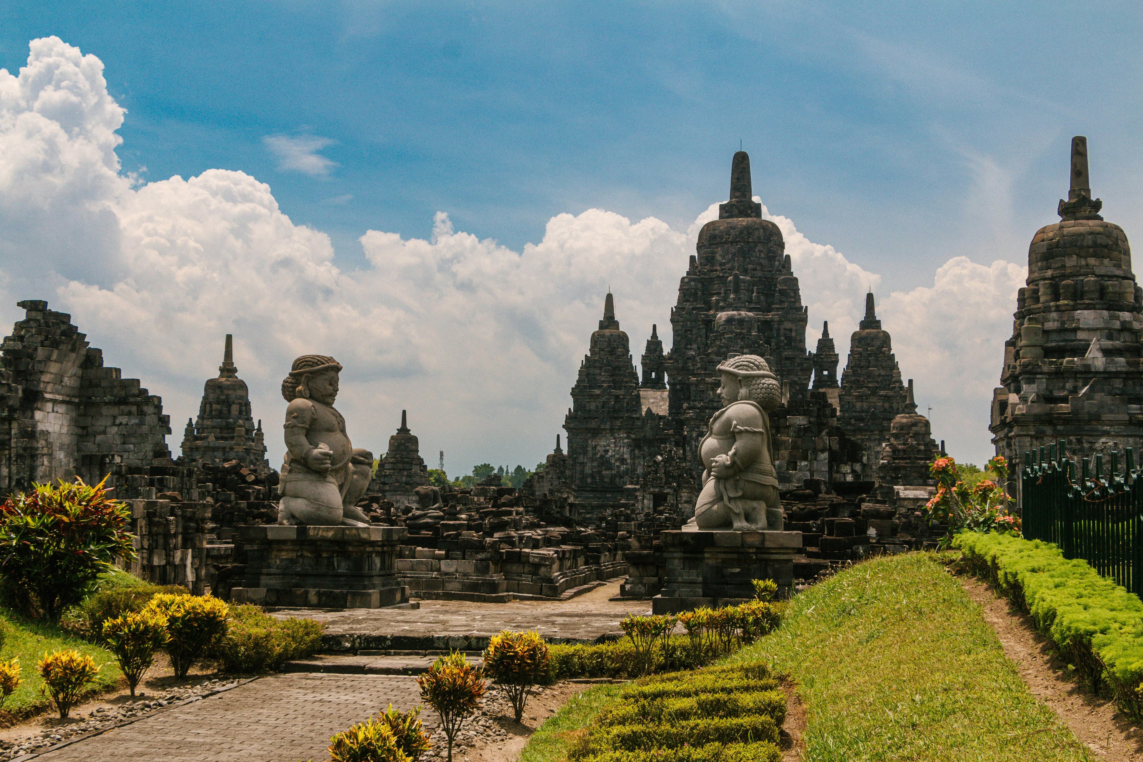 Stone statues in green field in Yogyakarta and Borobudur