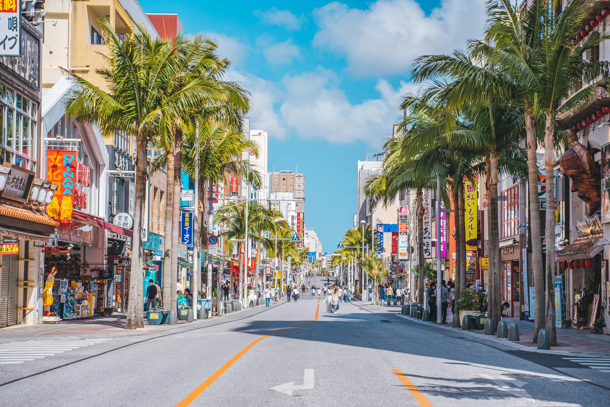 Street with colourful buildings and palm trees in Okinawa
