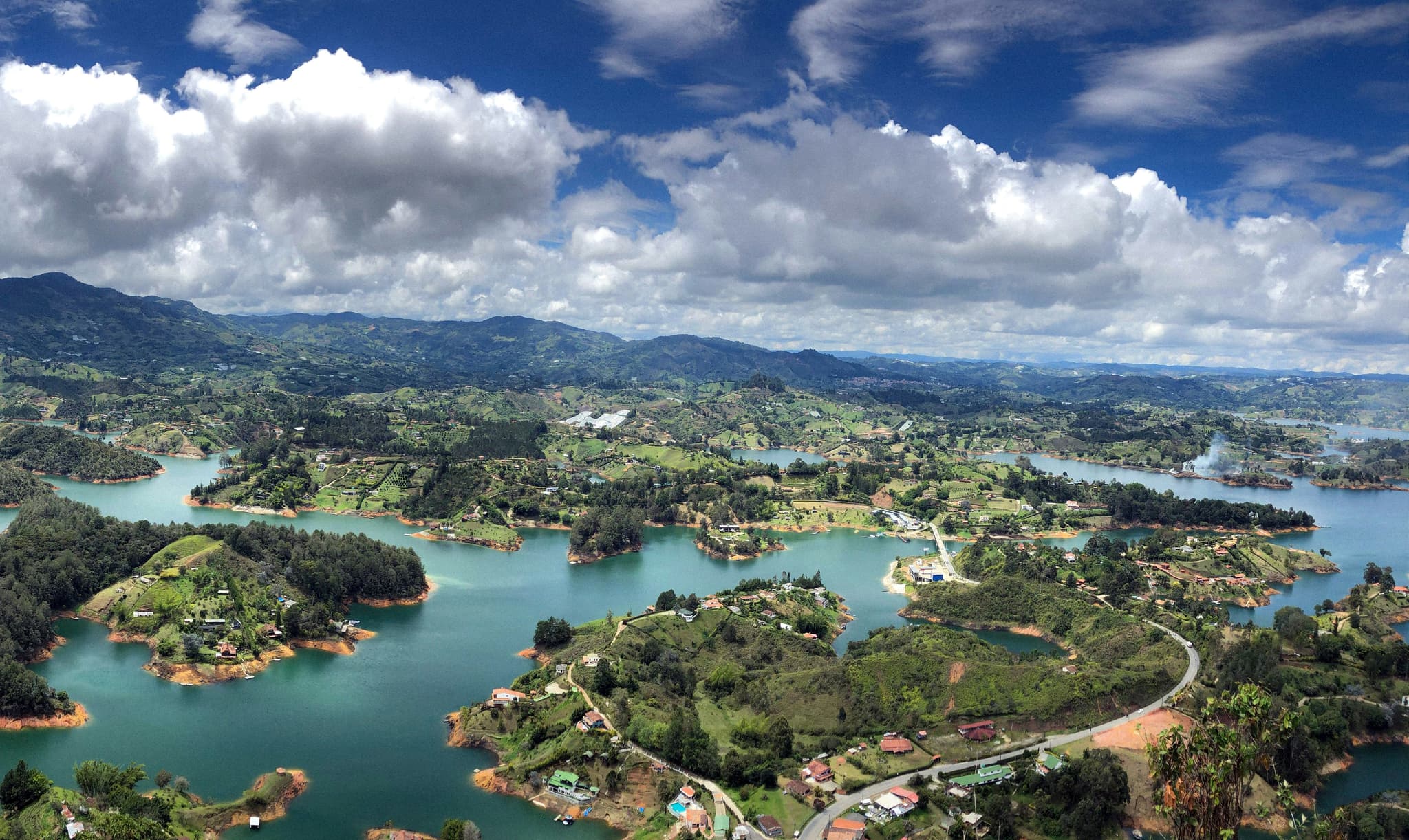 Aerial view of Guatape islands with blue water and white clouds in the air