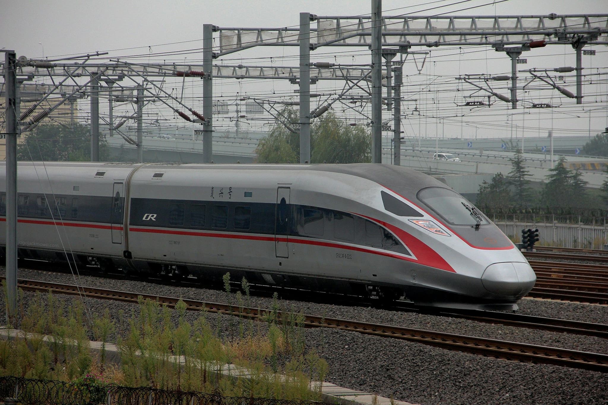 A white Fuxing CR400AF high-speed train leaving Qingdao North station