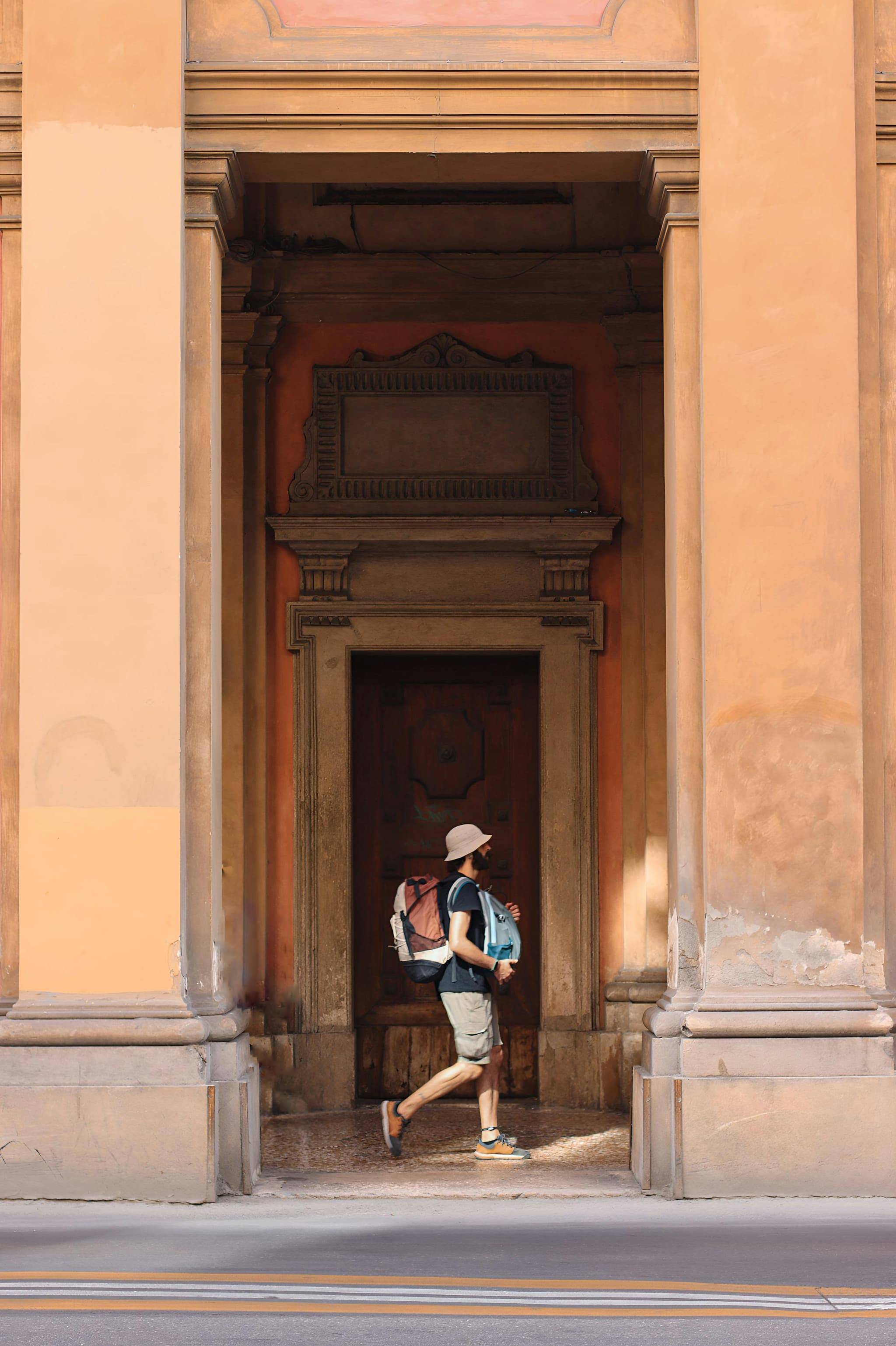man walking with backpack in city