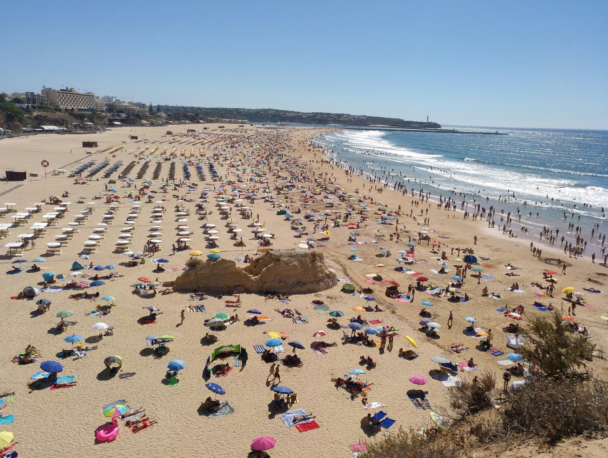 A beach with people and towels from above at Praia da Rocha