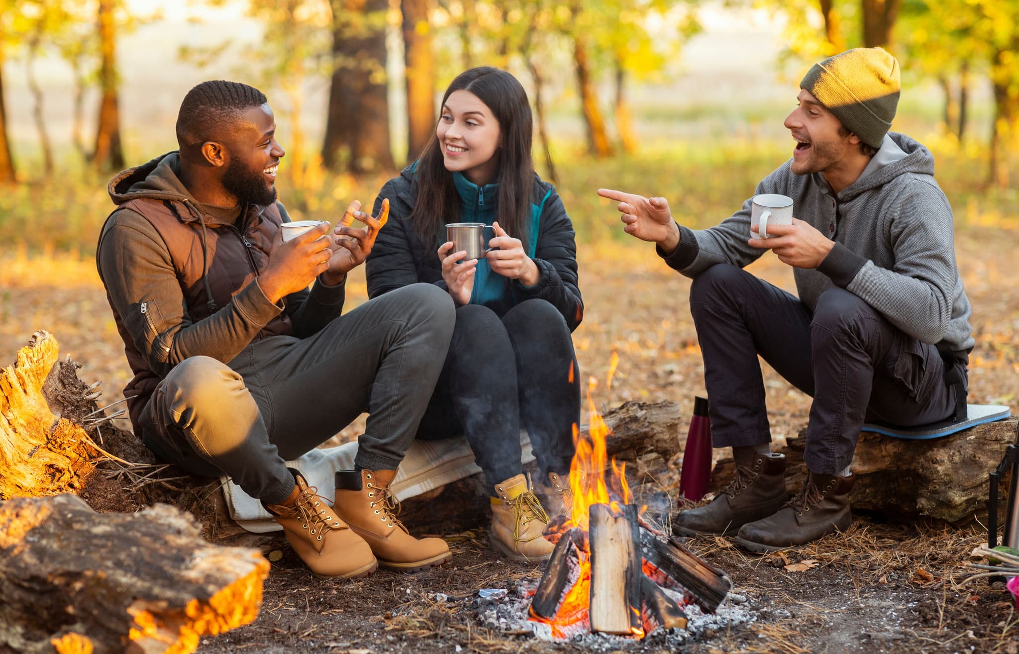 people sitting talking around bonfire