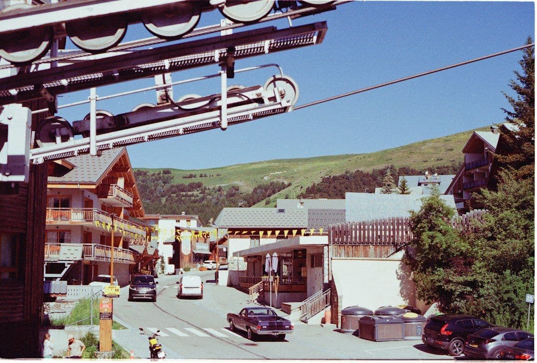 A ski lift running over a snowy street in an Alpine mountain village.
