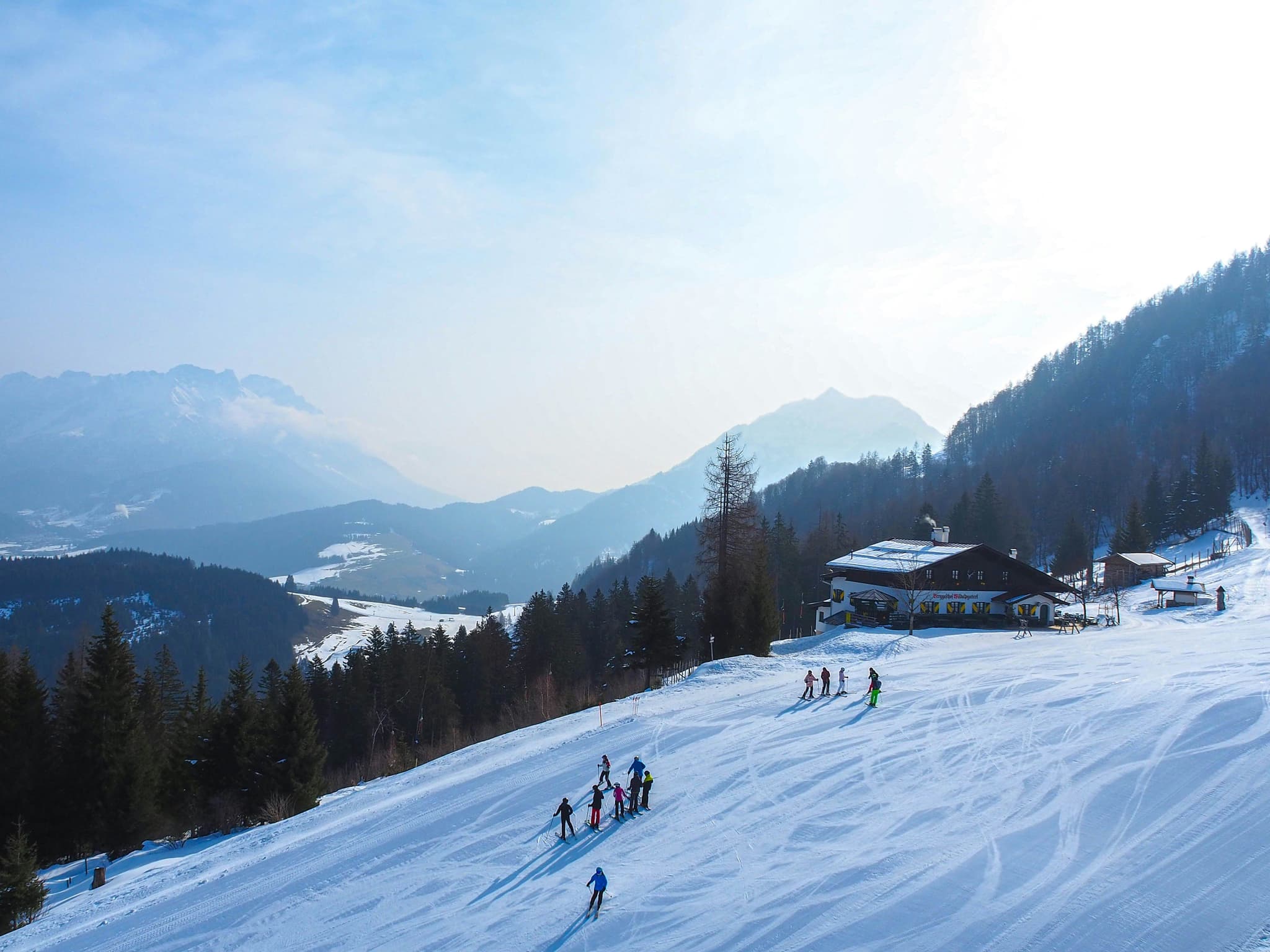 Snow covered mountain with skii people on a misty day in Austria