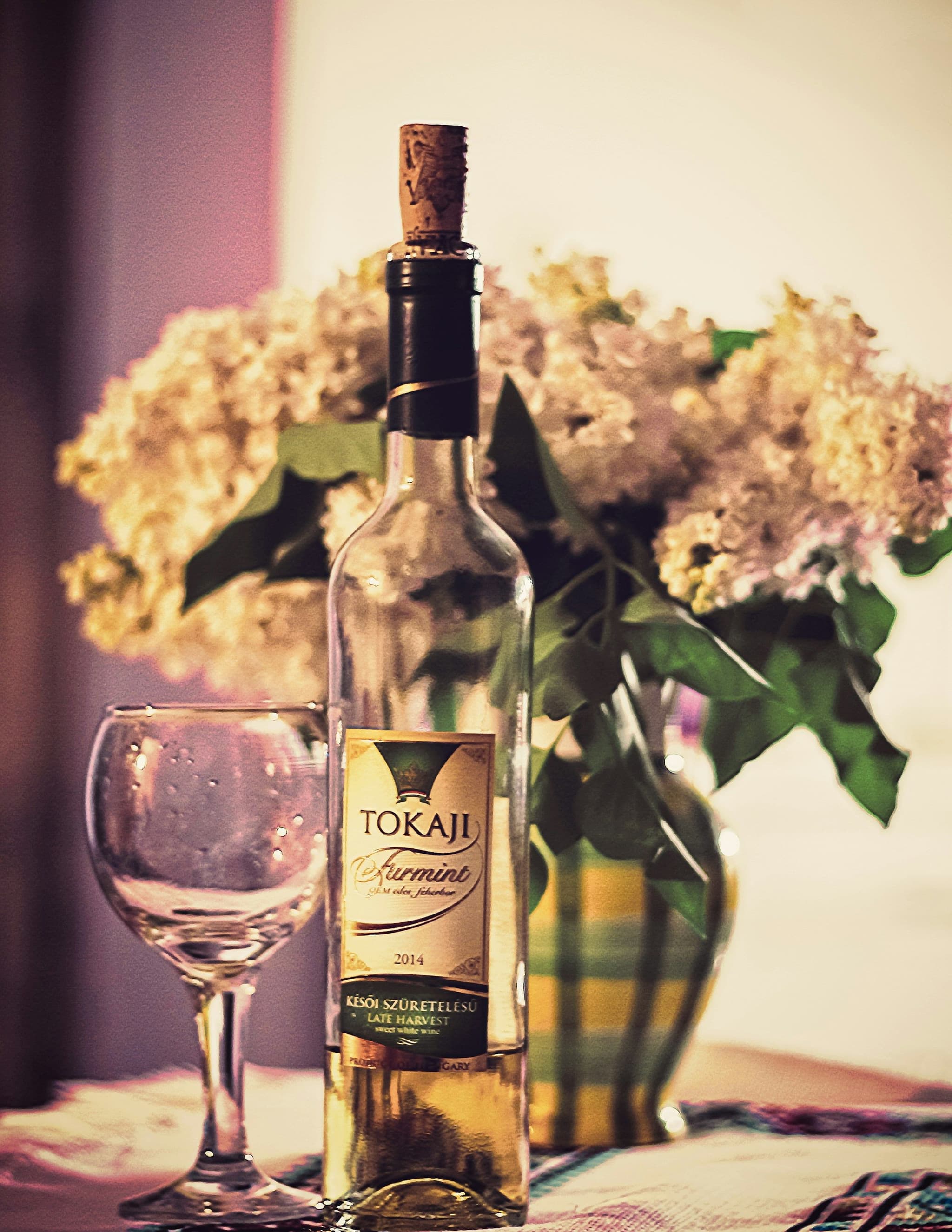A bottle of Tokaji wine beside a wine glass