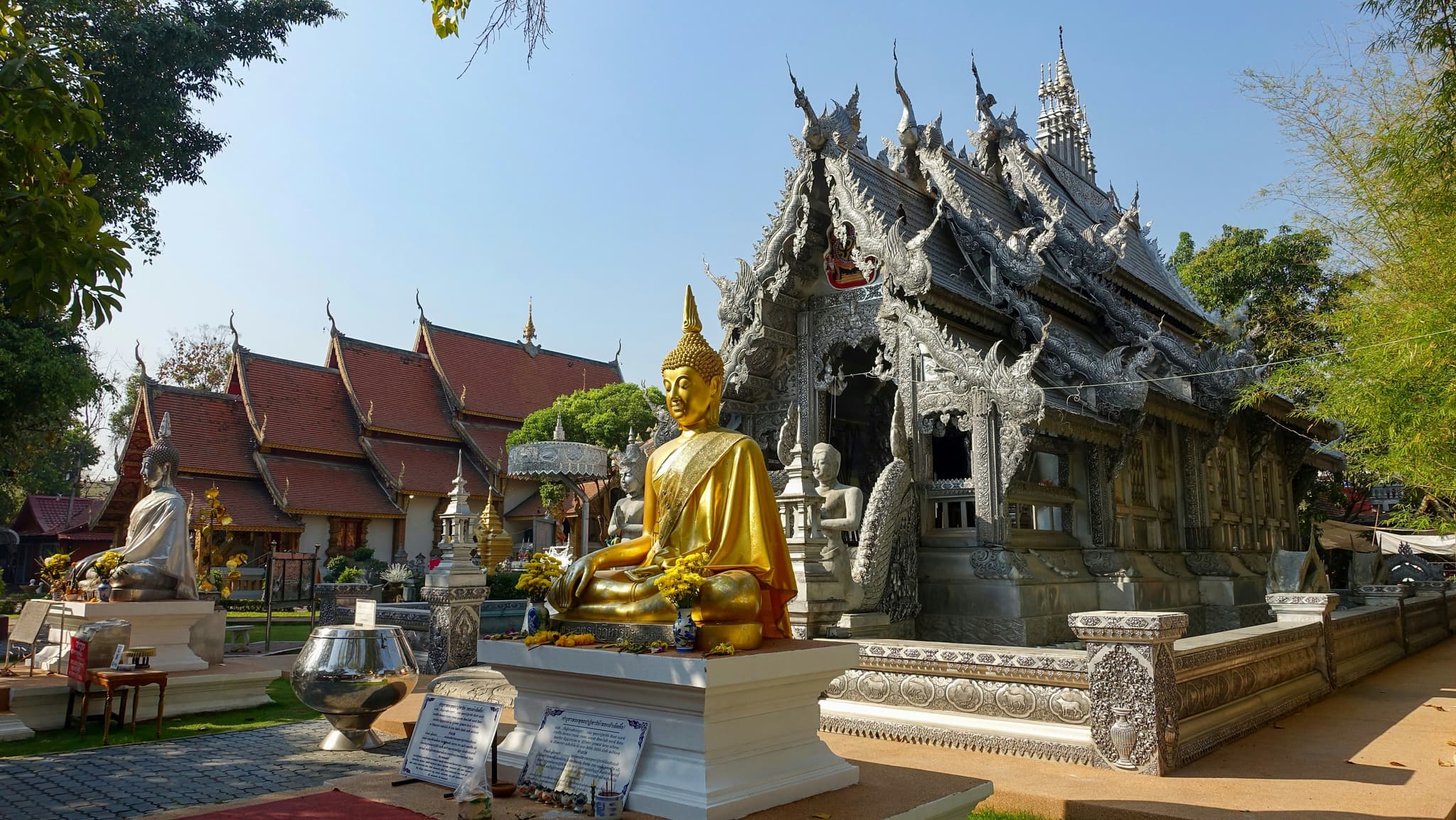Golden buddha statue in front of a grey temple in Chiang Mai Old City