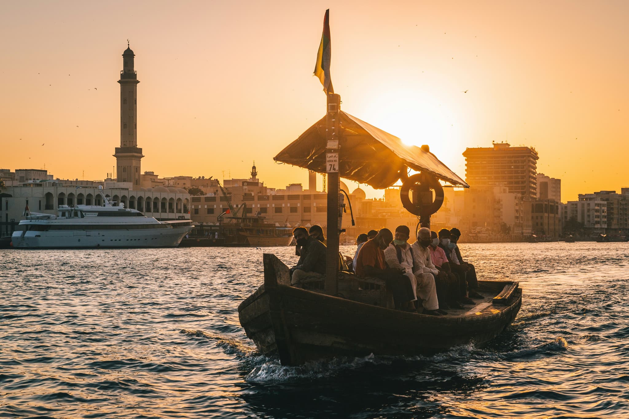 People during a dhow boat ride at sunset on the water