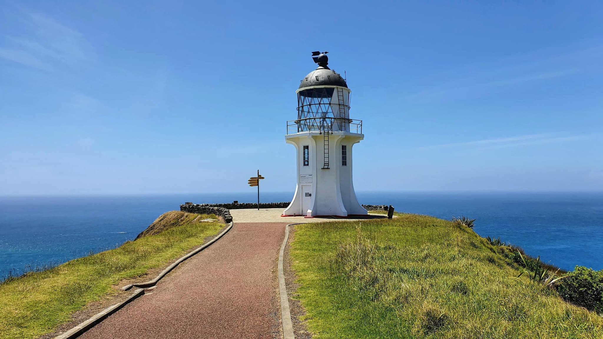 A path to a white lighthouse in Cape Reinga on a sunny day