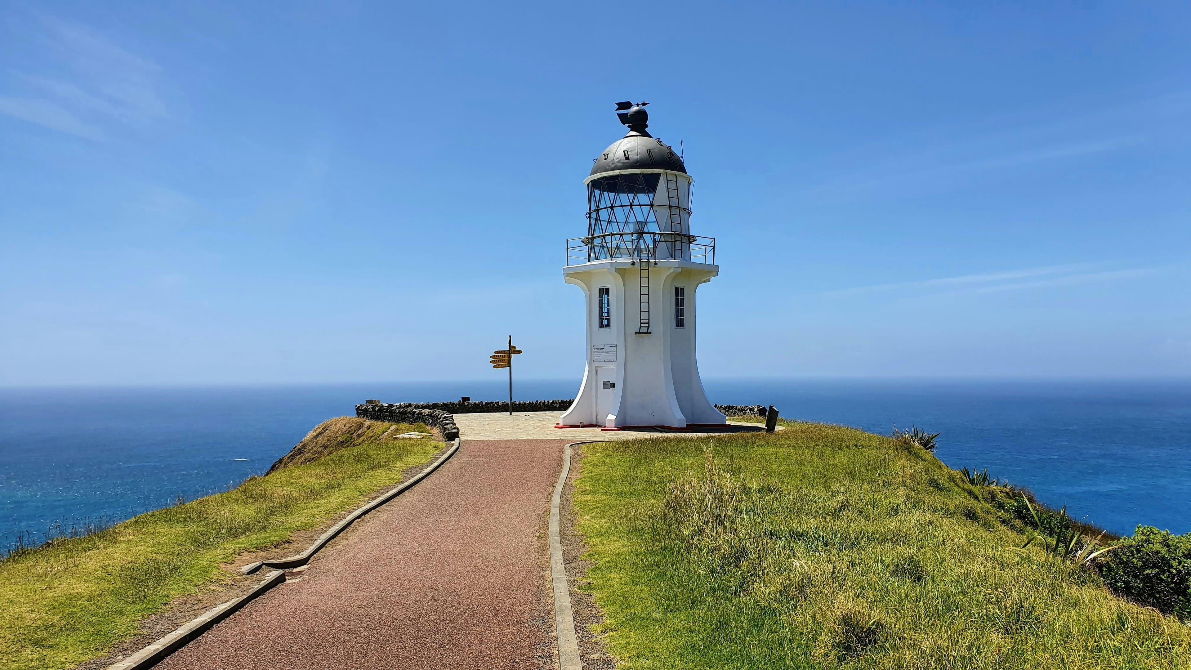 A path to a white lighthouse in Cape Reinga on a sunny day