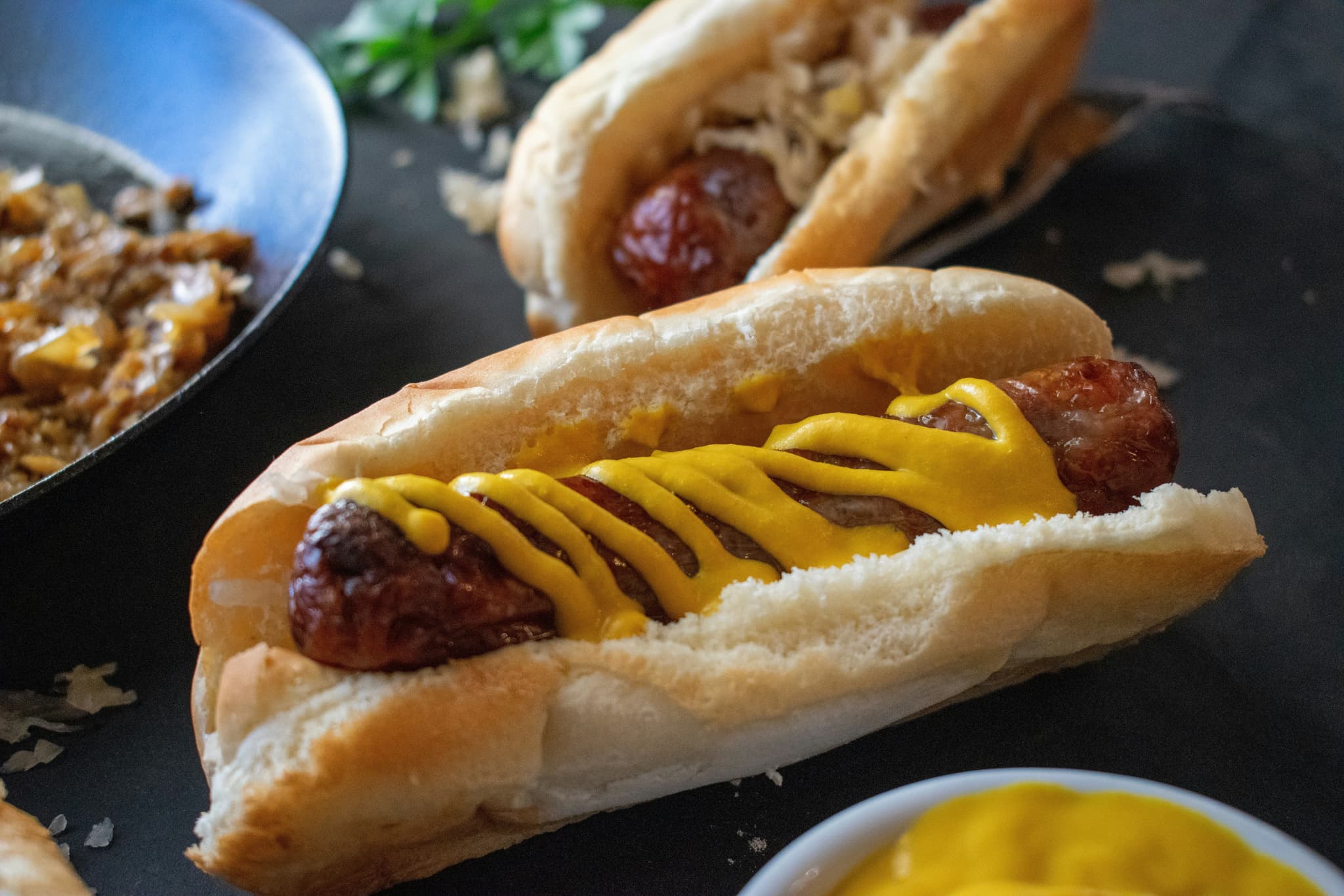 Hot dog in a soft bread with mustard sauce