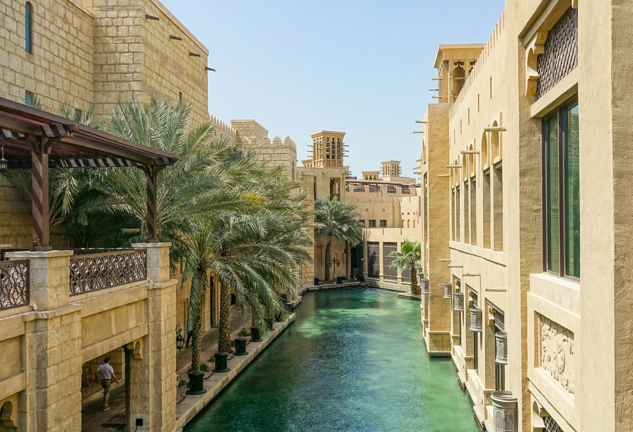 Buildings in old Dubai with a small blue pool and palm trees