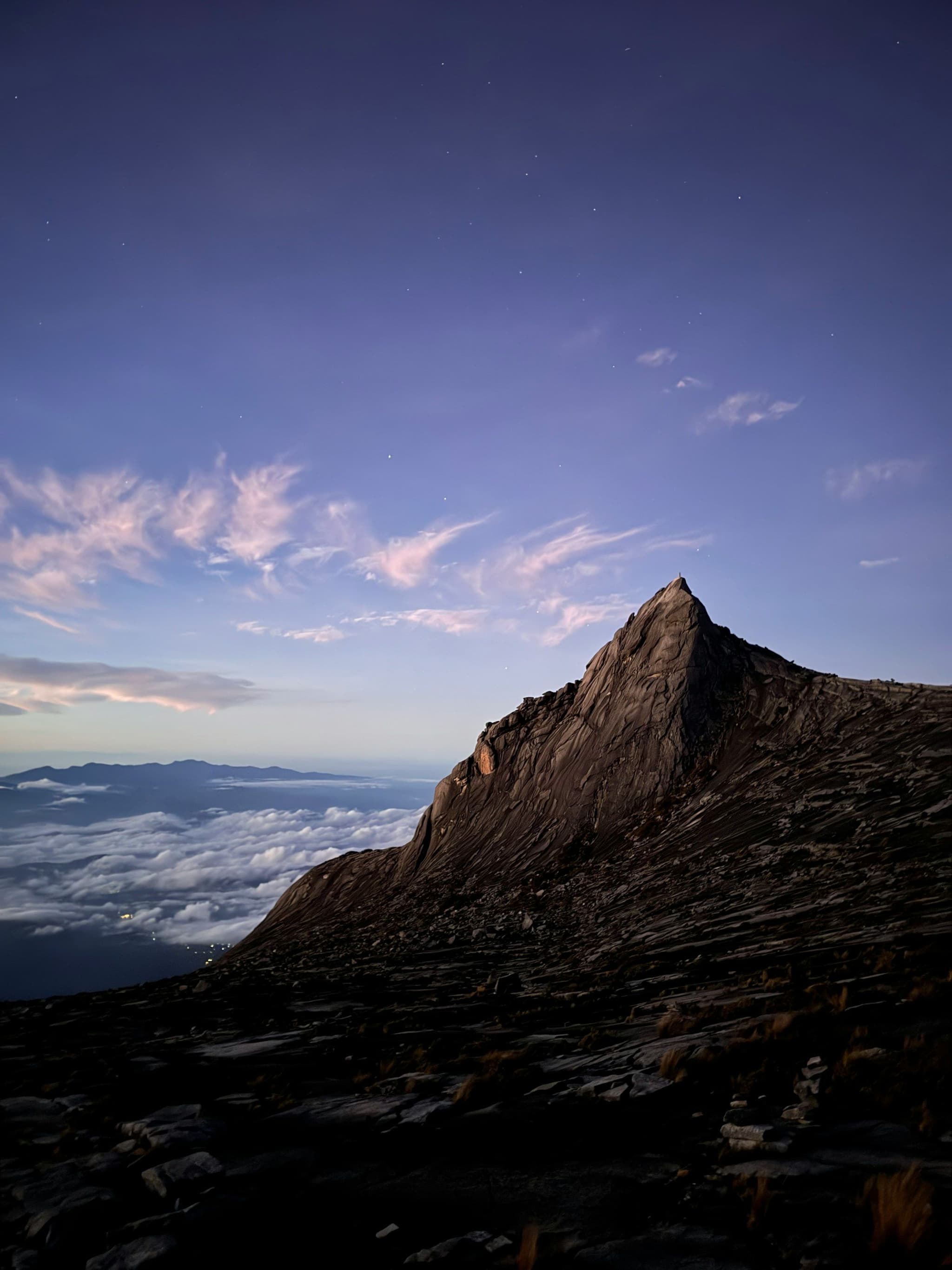 The summit rocks of Mount Kinabalu at sunrise above the clouds