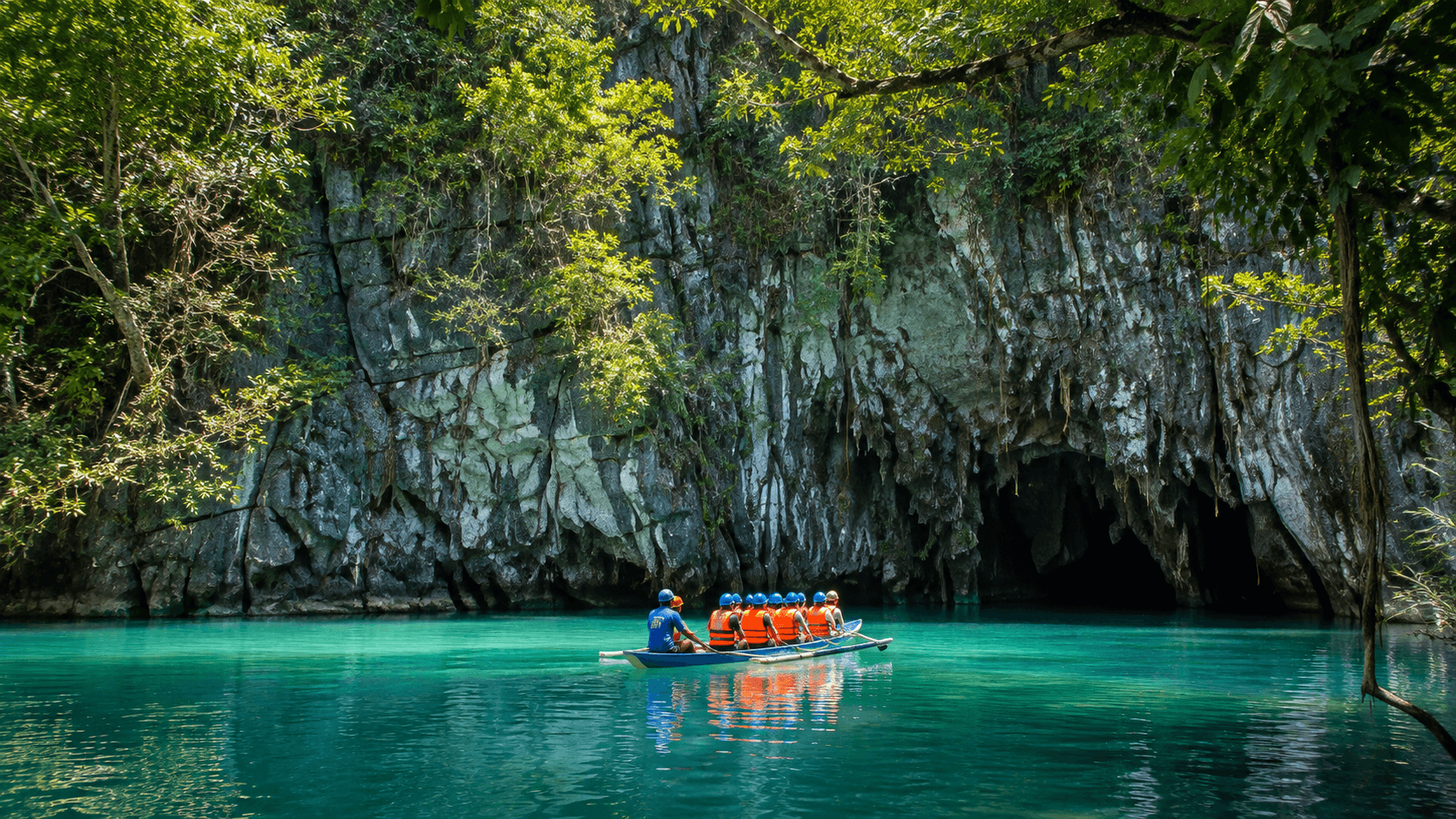 A boat with people with lifevests heading toward a cave to explore in the waters of philippines