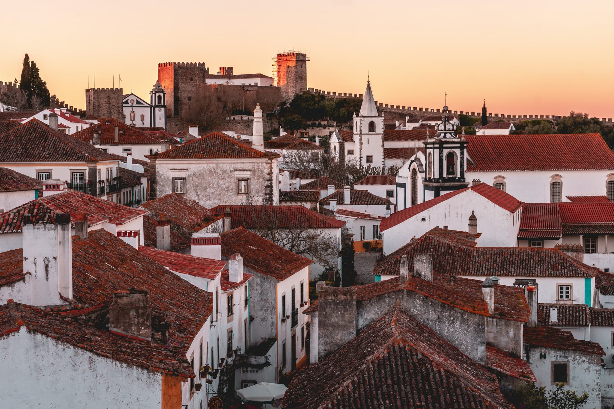colourful red roofs and tiny white houses in Óbidos during sunset